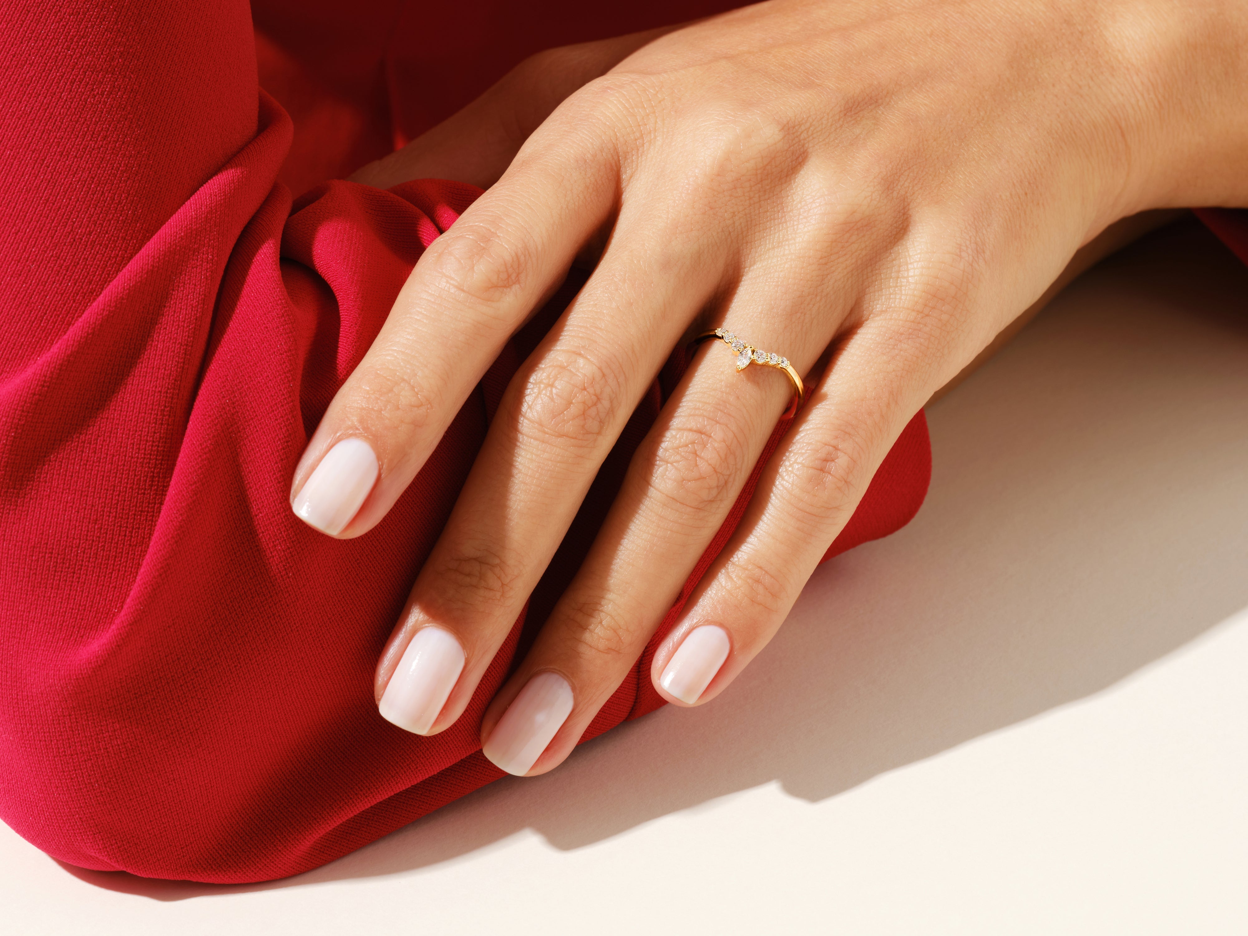 Diamond chevron ring on a hand with red fabric