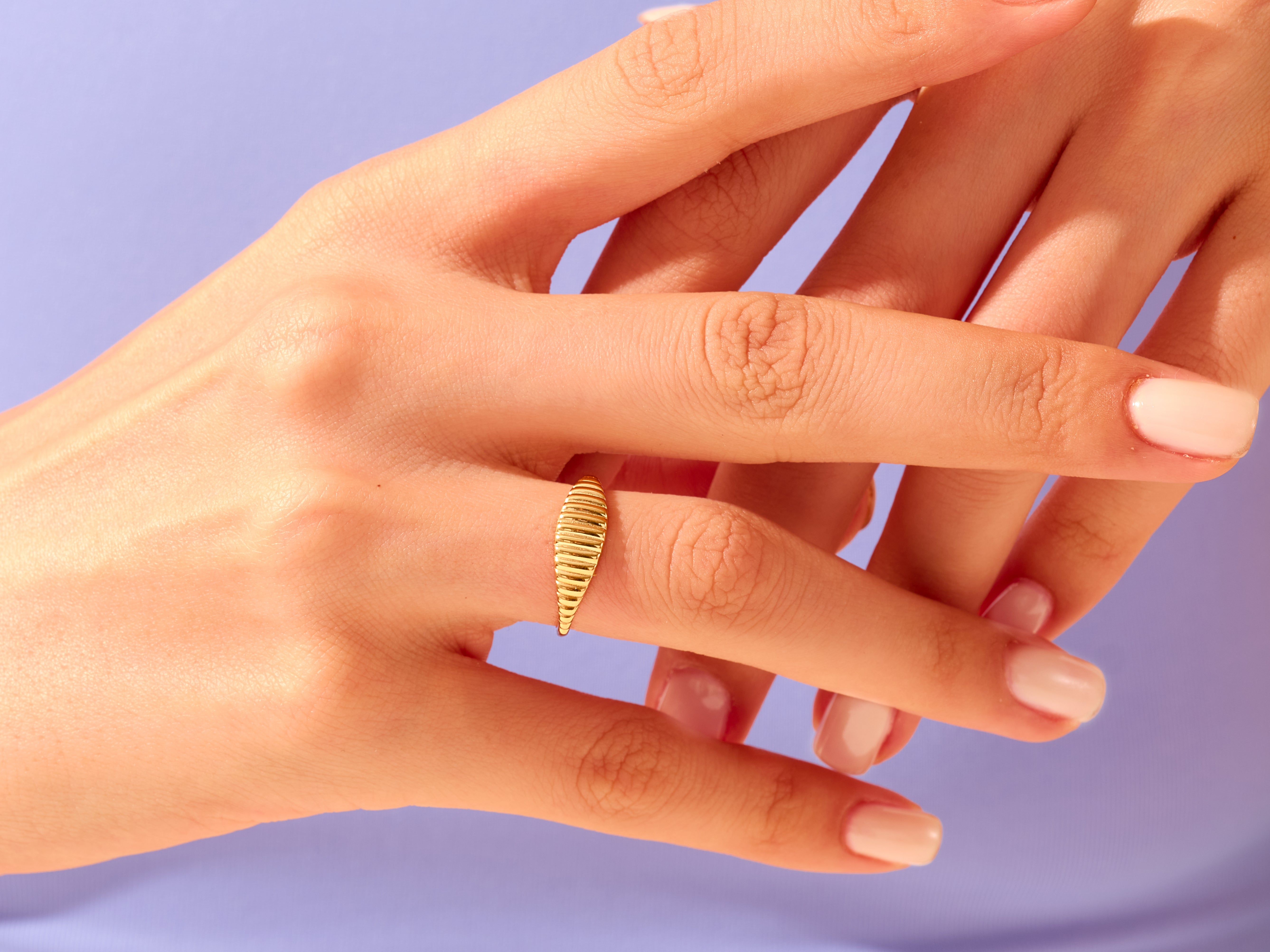 Gold ribbed ring on a hand, jewelry for women