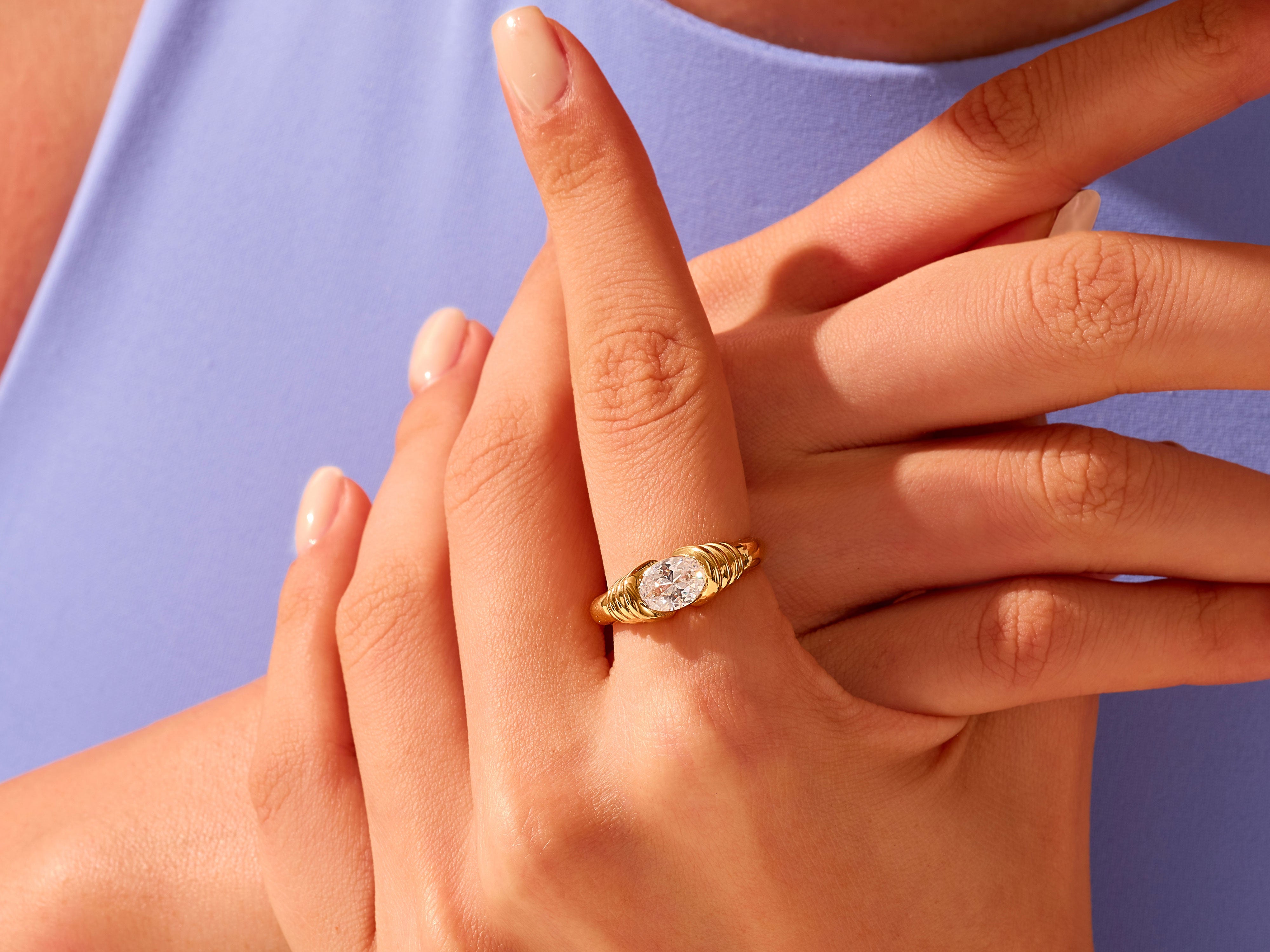 Gold ring with oval diamond on hand