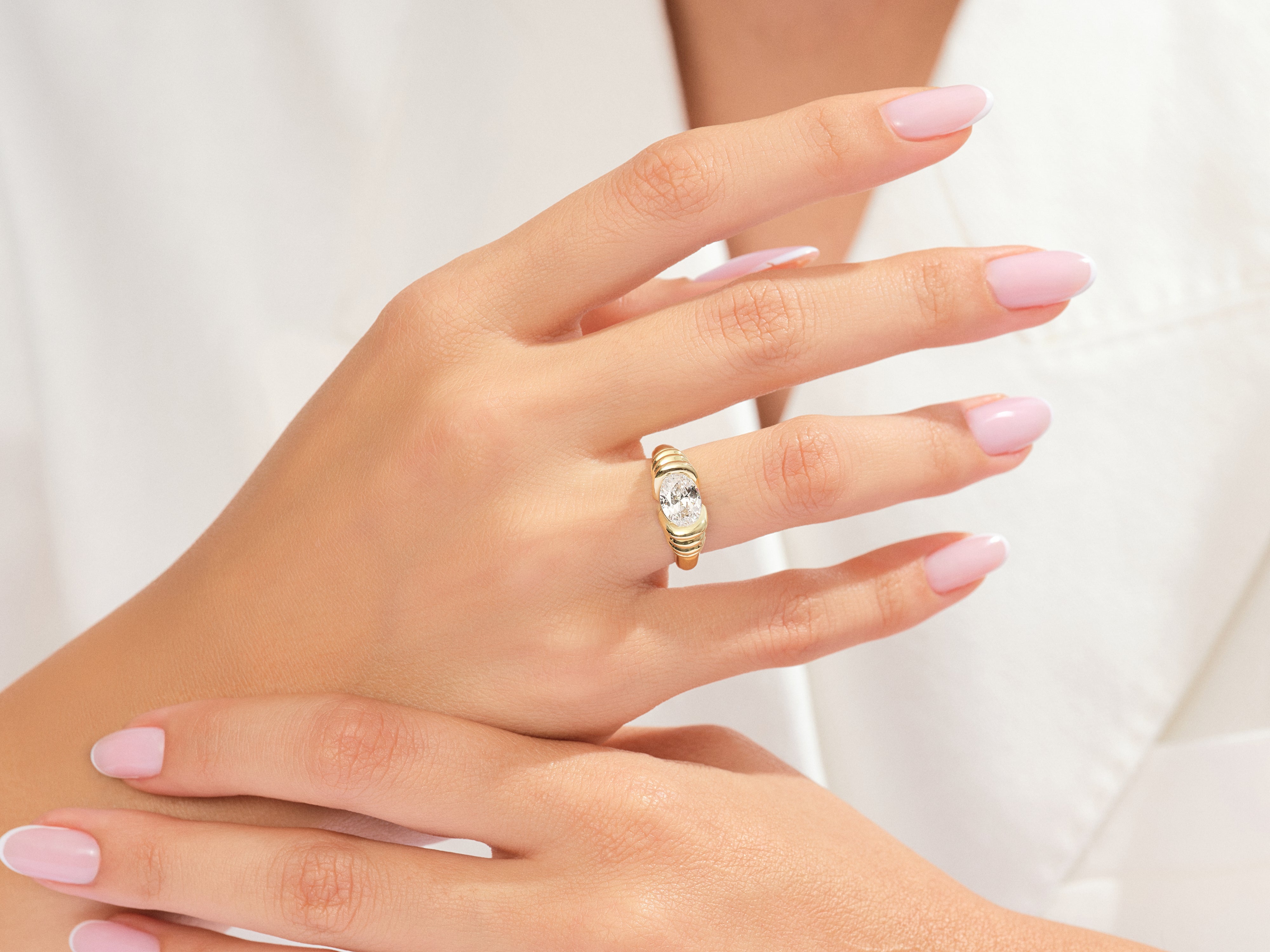 Gold ring with oval diamond on a woman's hand