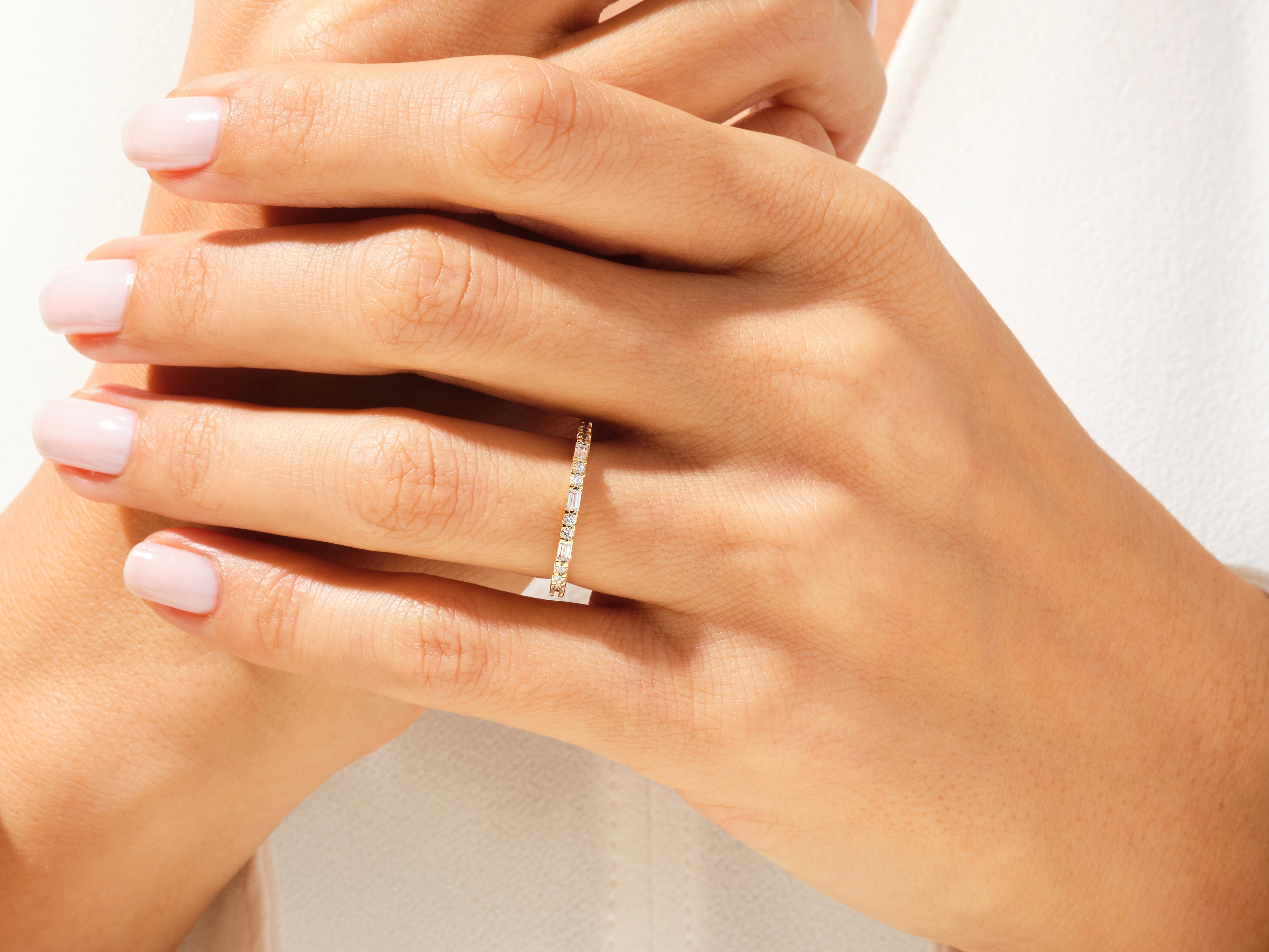 Diamond eternity band on a hand, fine jewelry for women