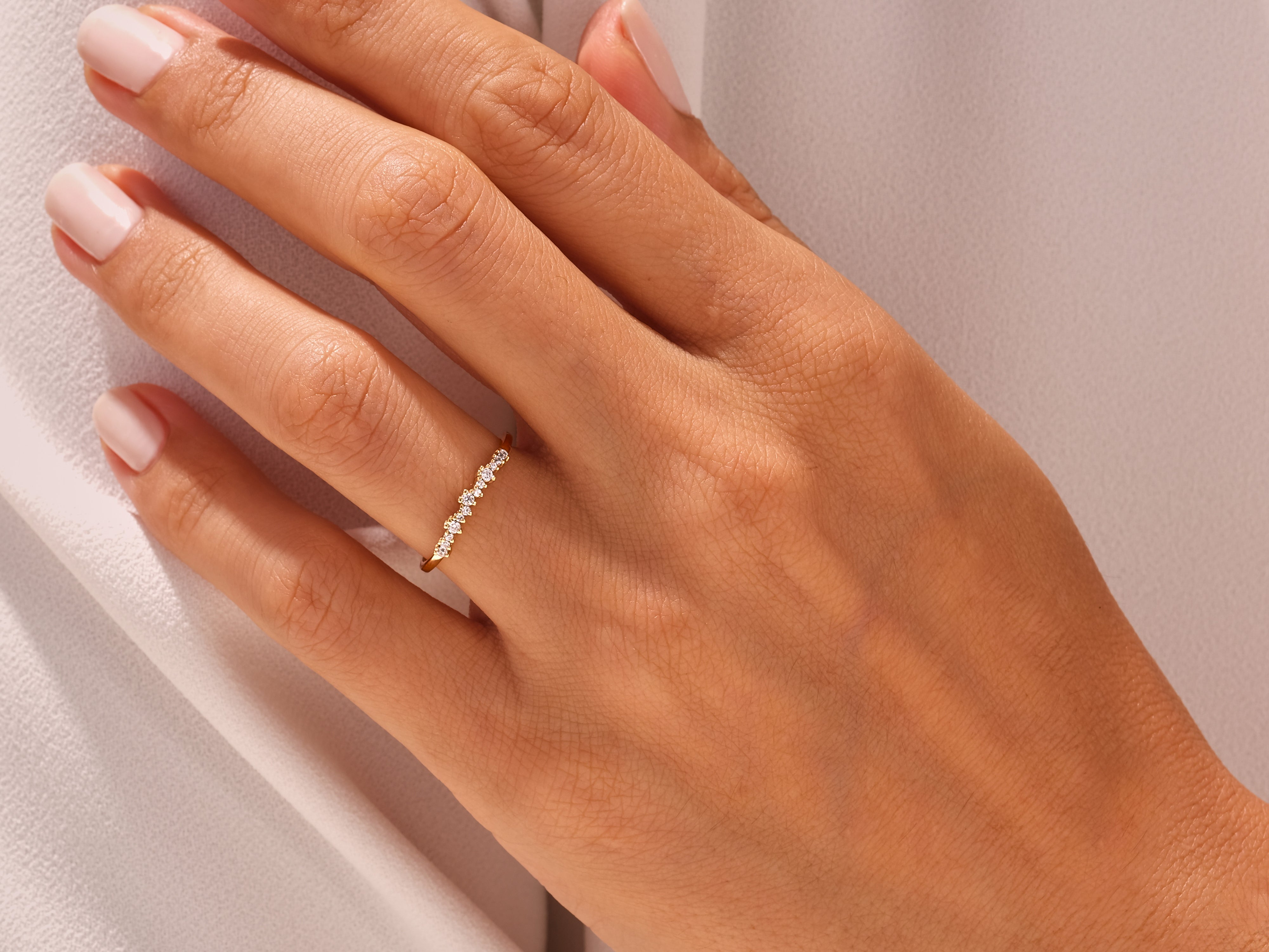 Delicate diamond band ring on a woman's finger, jewelry