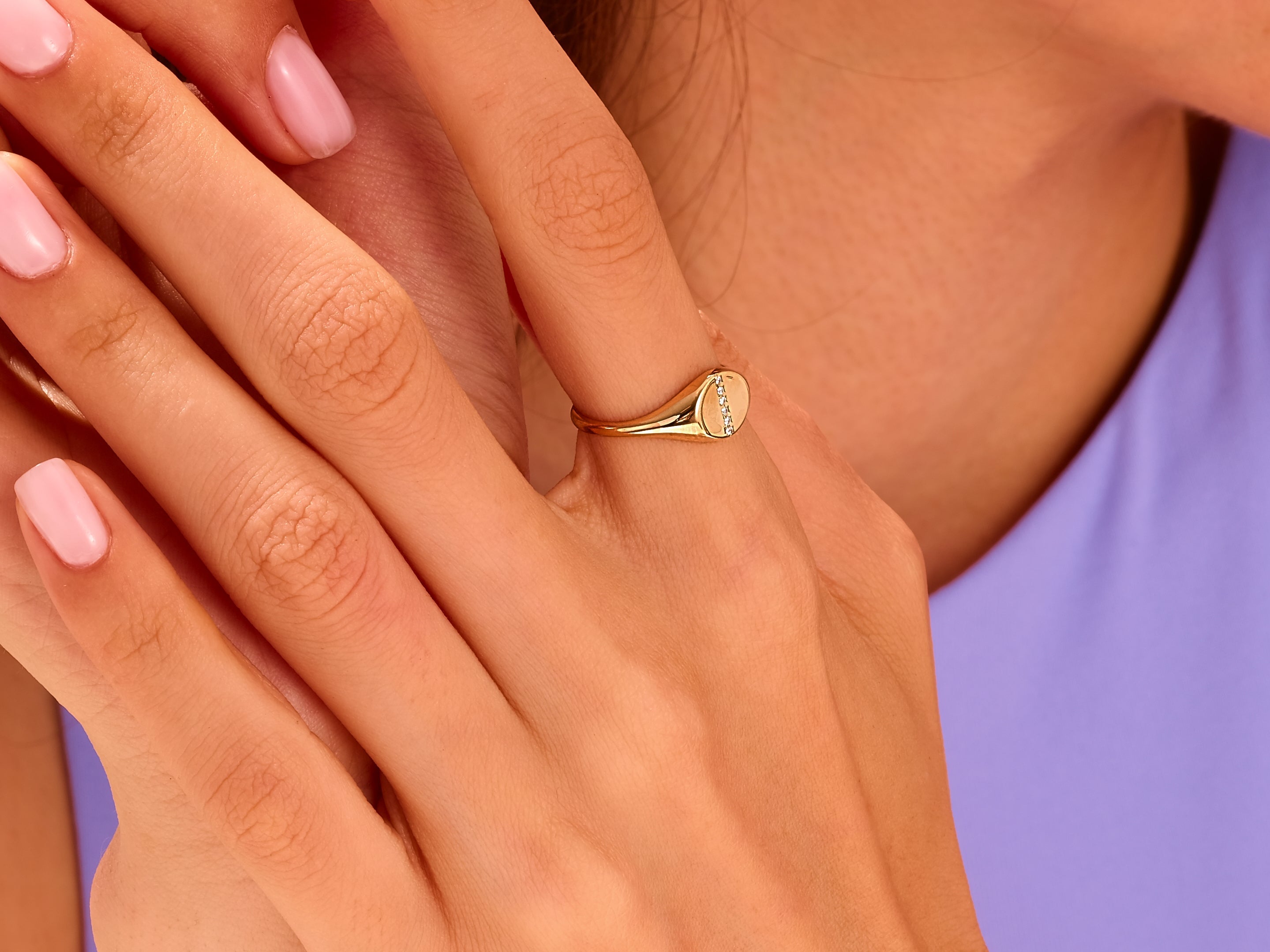 Gold signet ring with diamonds on a woman's hand
