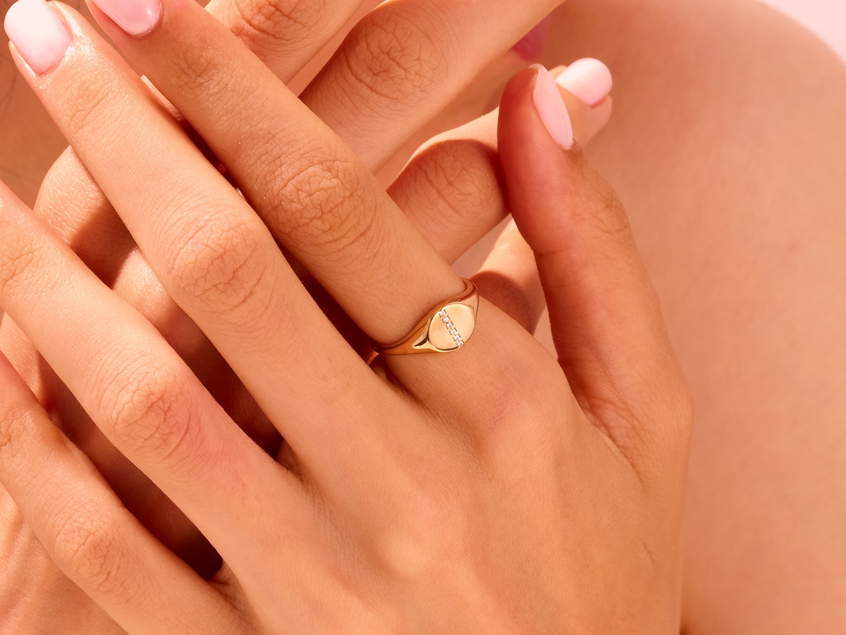Gold signet ring with diamonds on a woman's hand