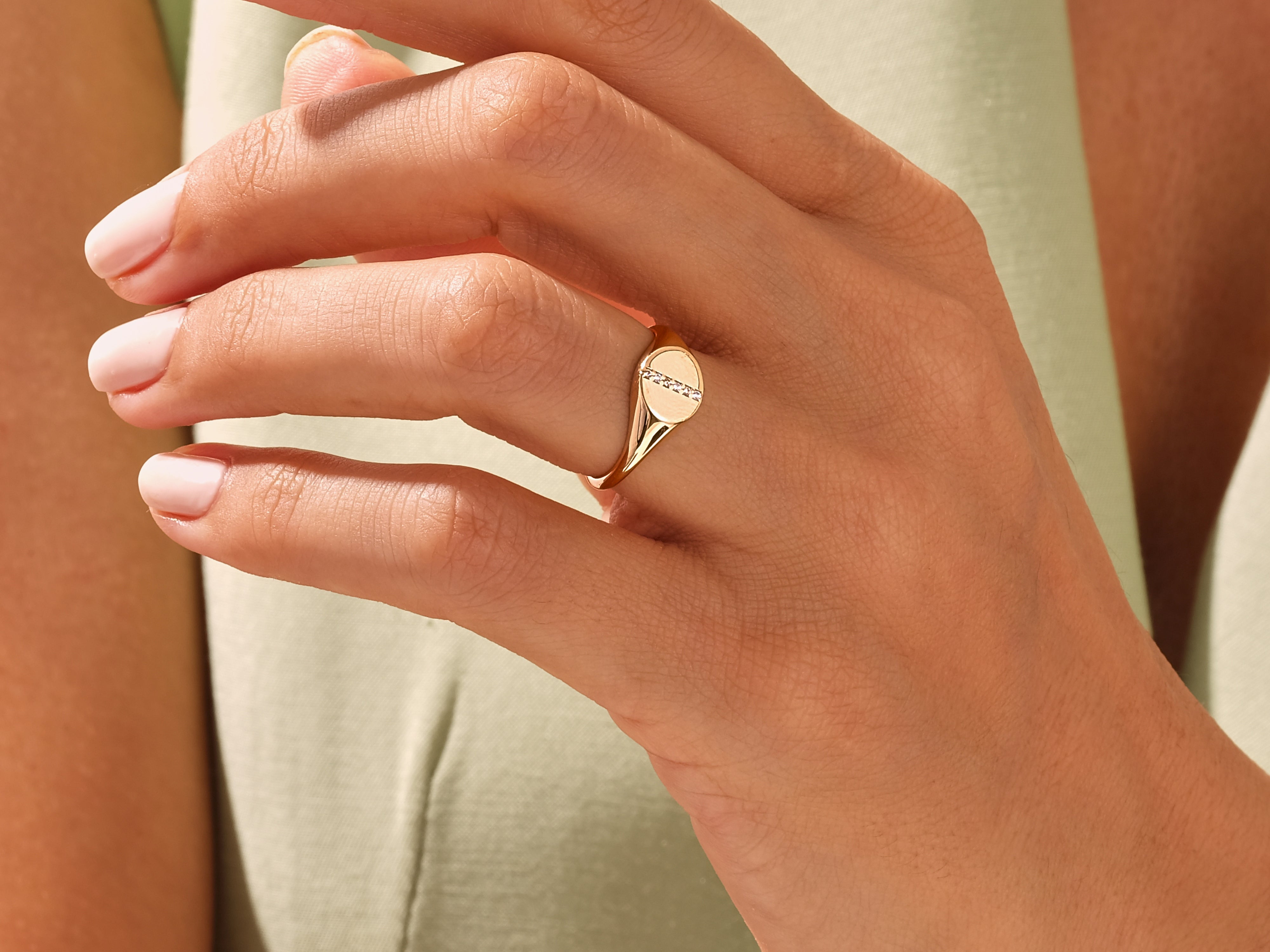 Gold signet ring with diamonds on a woman's finger