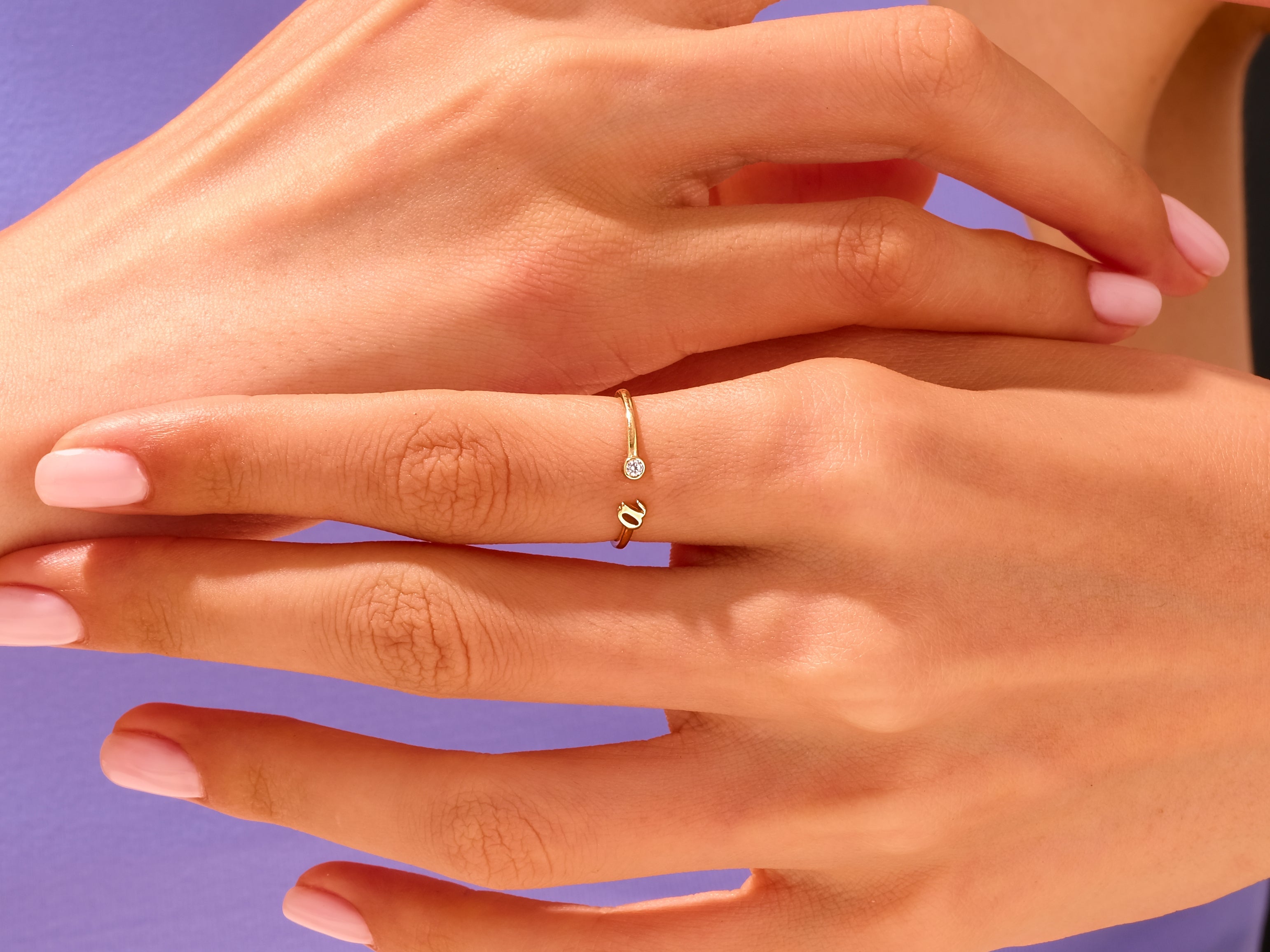 Delicate gold ring with diamond accent on hand