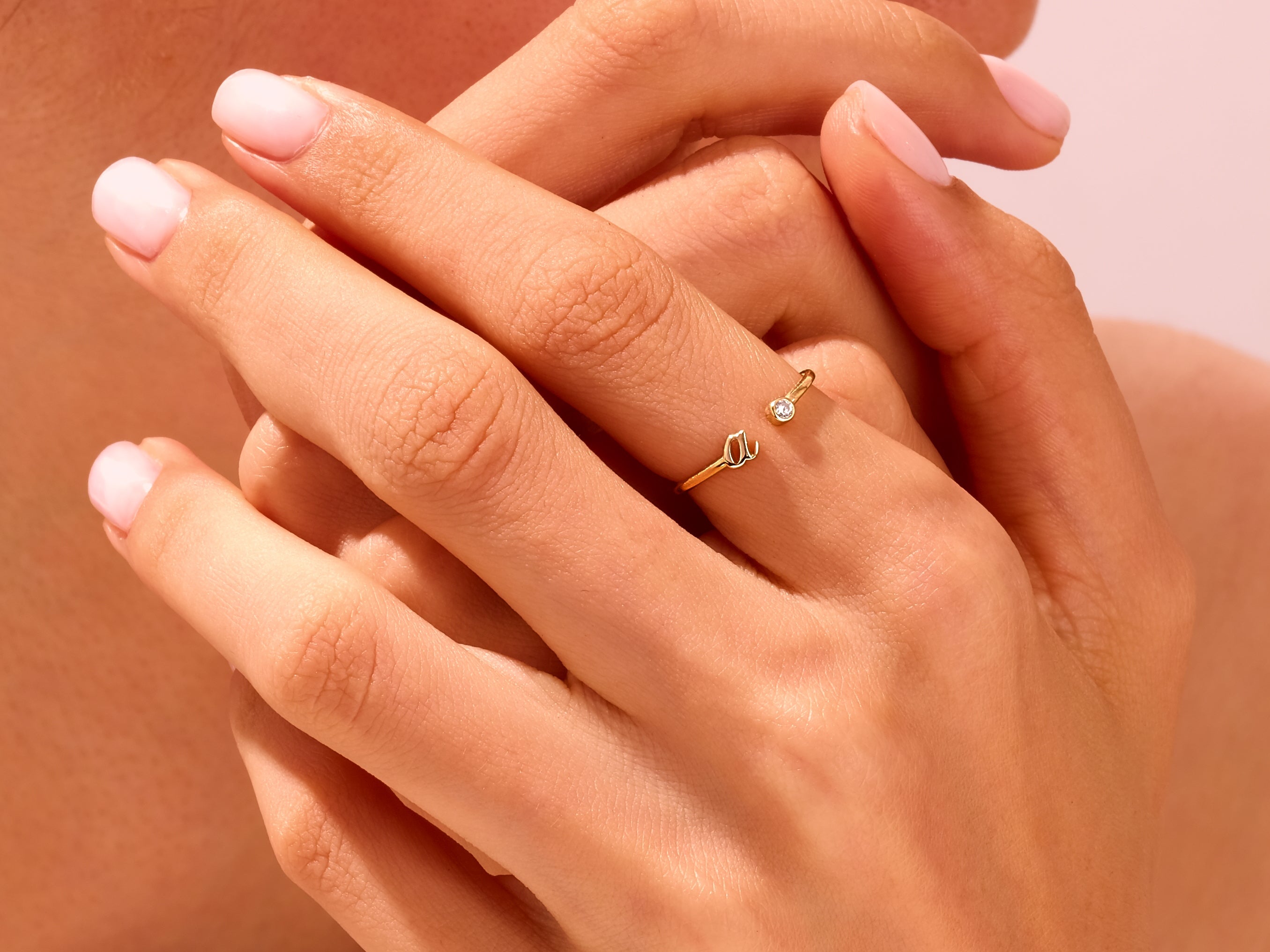 Gold initial ring with diamond accent on hand