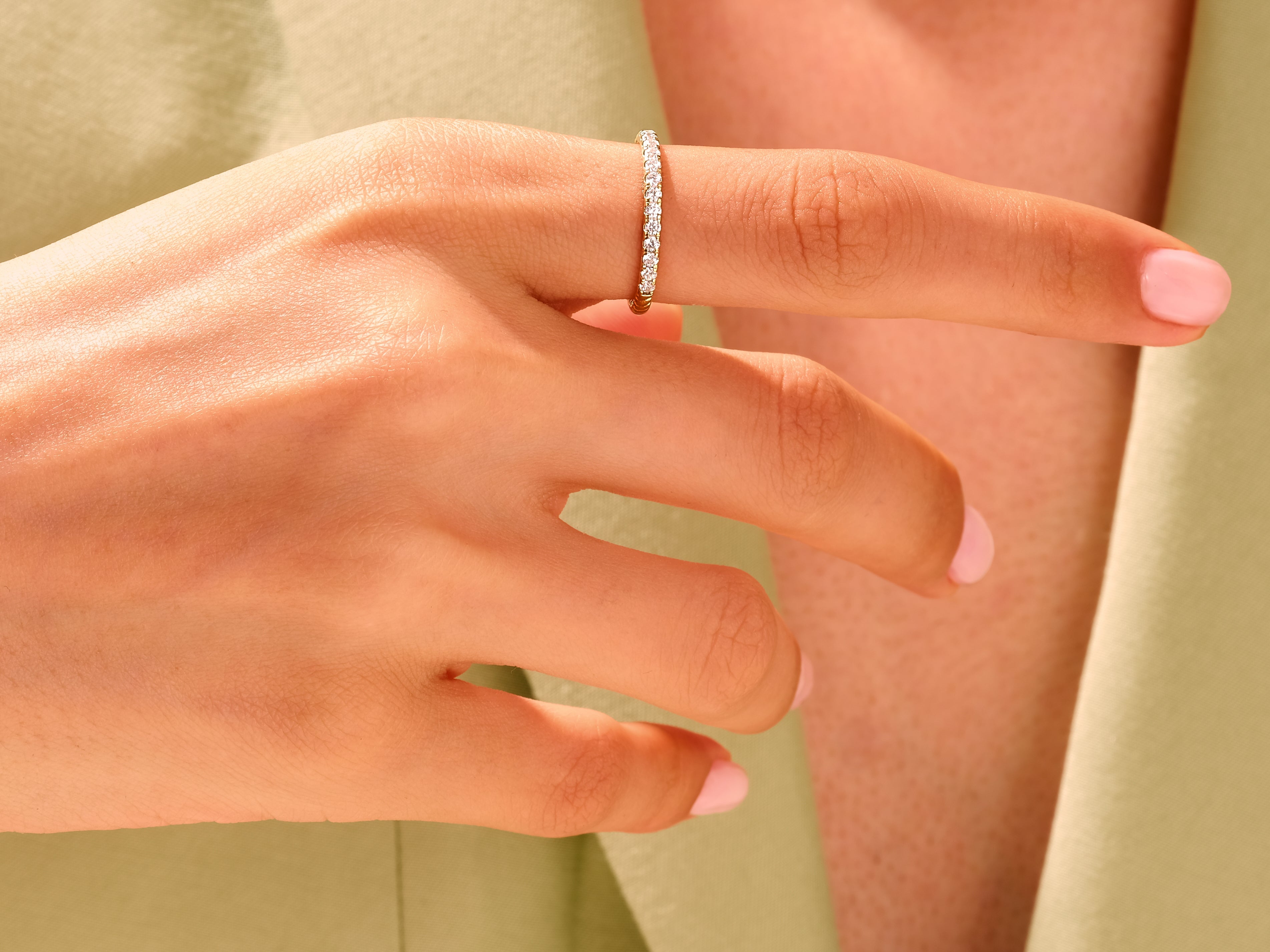 Diamond eternity ring on a woman's finger, jewelry product photography