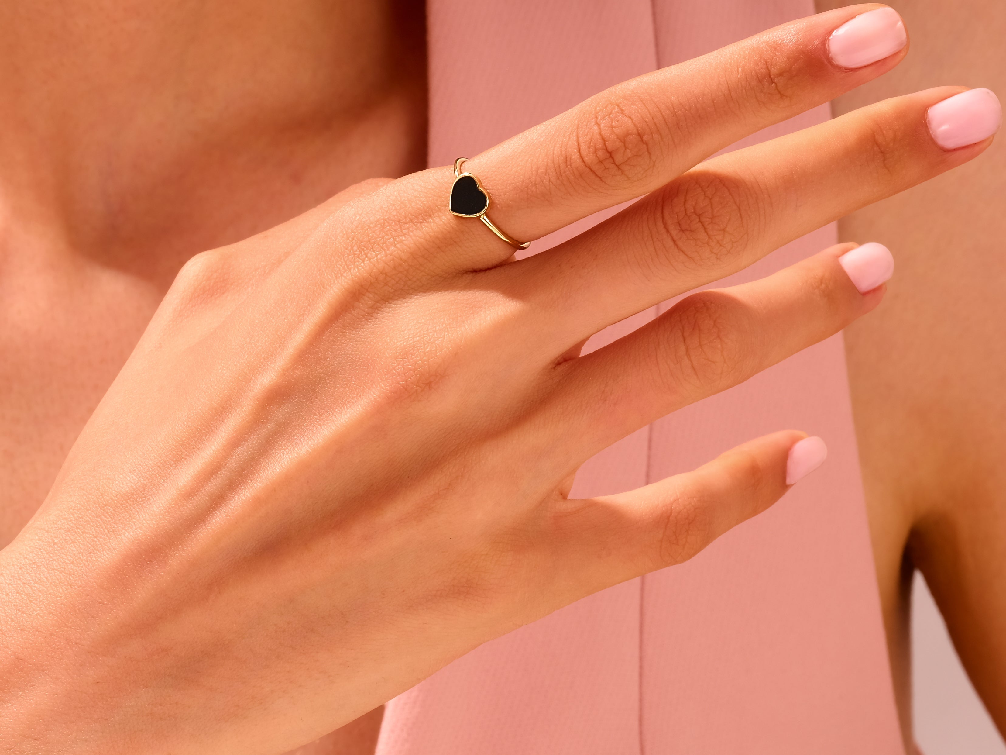 Gold heart ring with black enamel on a woman's hand