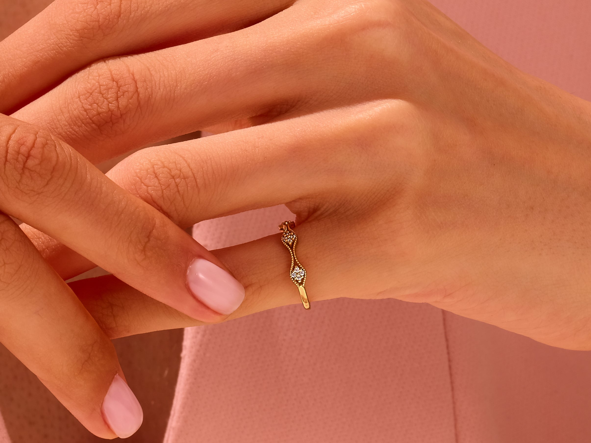 Delicate gold ring with diamonds on a woman's hand