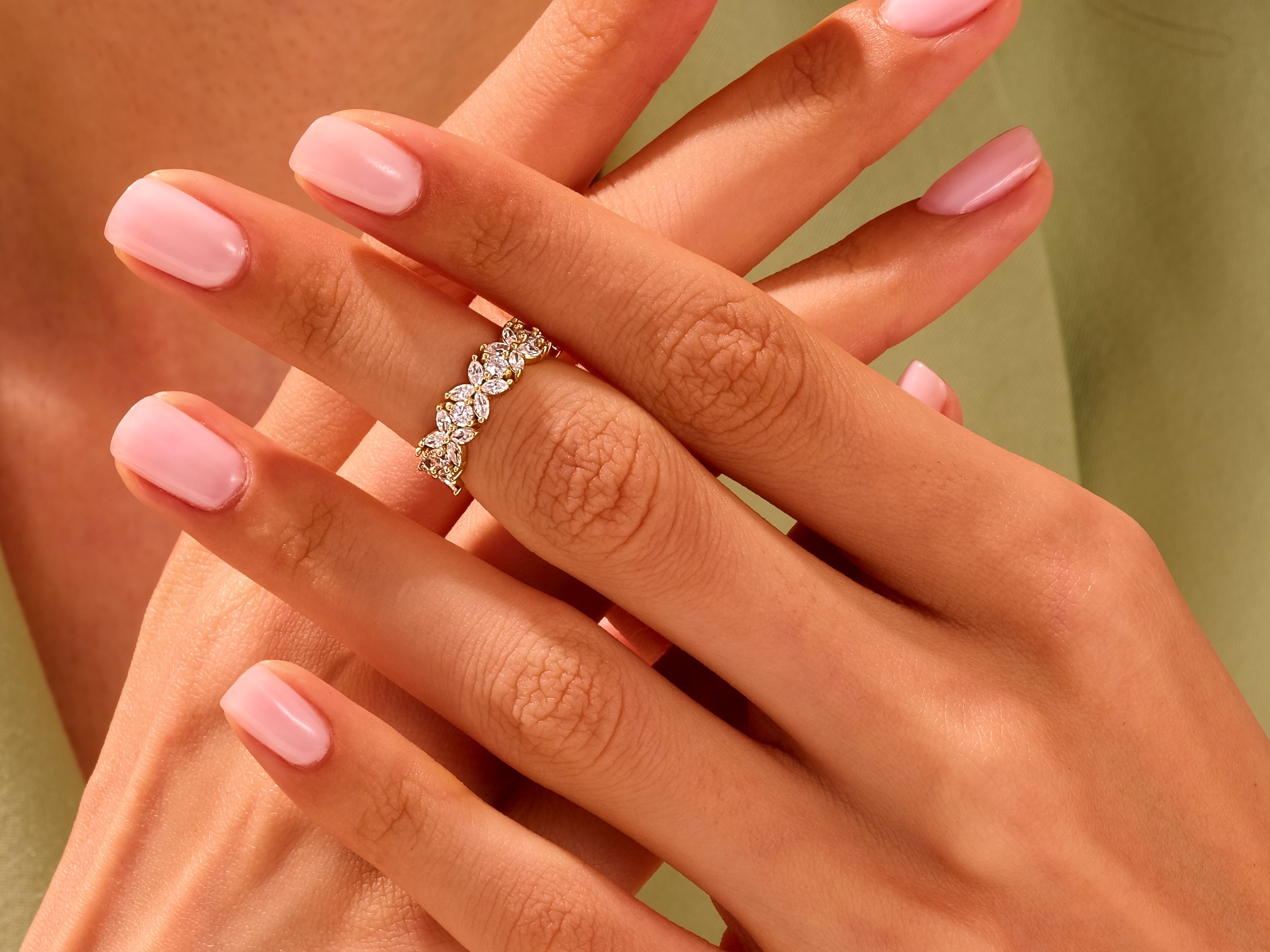 Diamond flower ring on a hand with pink nails