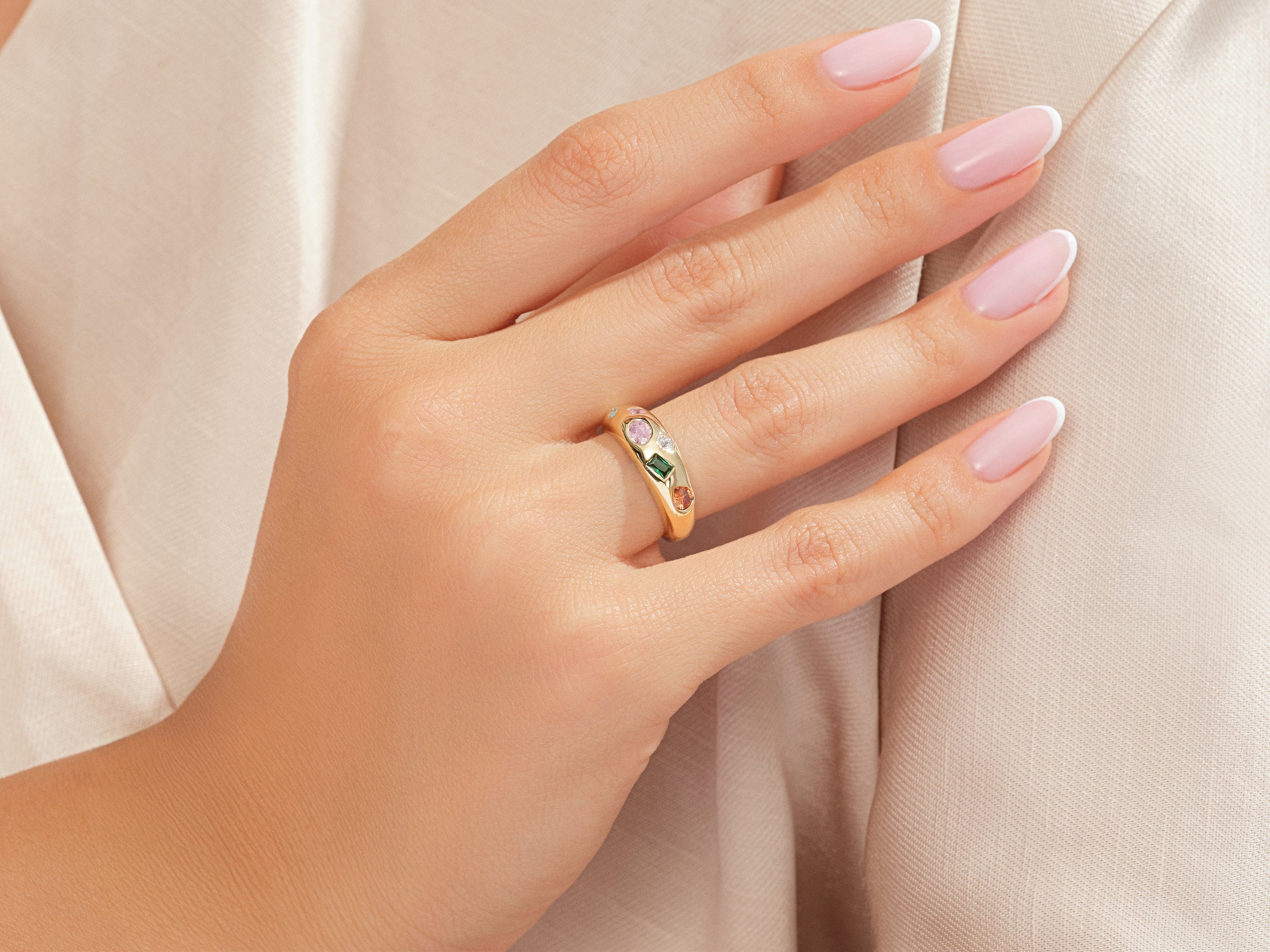 Gold ring with colorful gemstones on a woman's hand