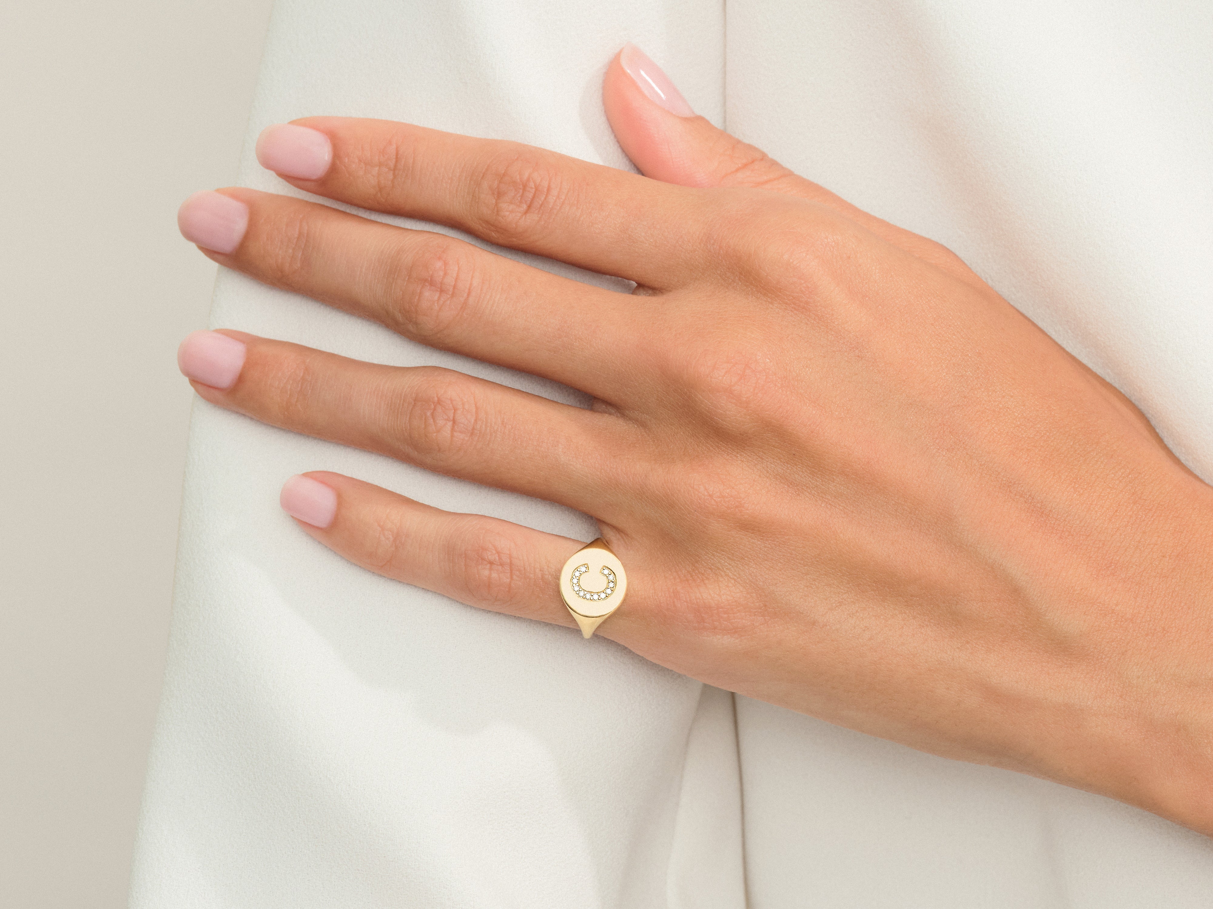 Gold horseshoe ring with diamonds on a woman's hand