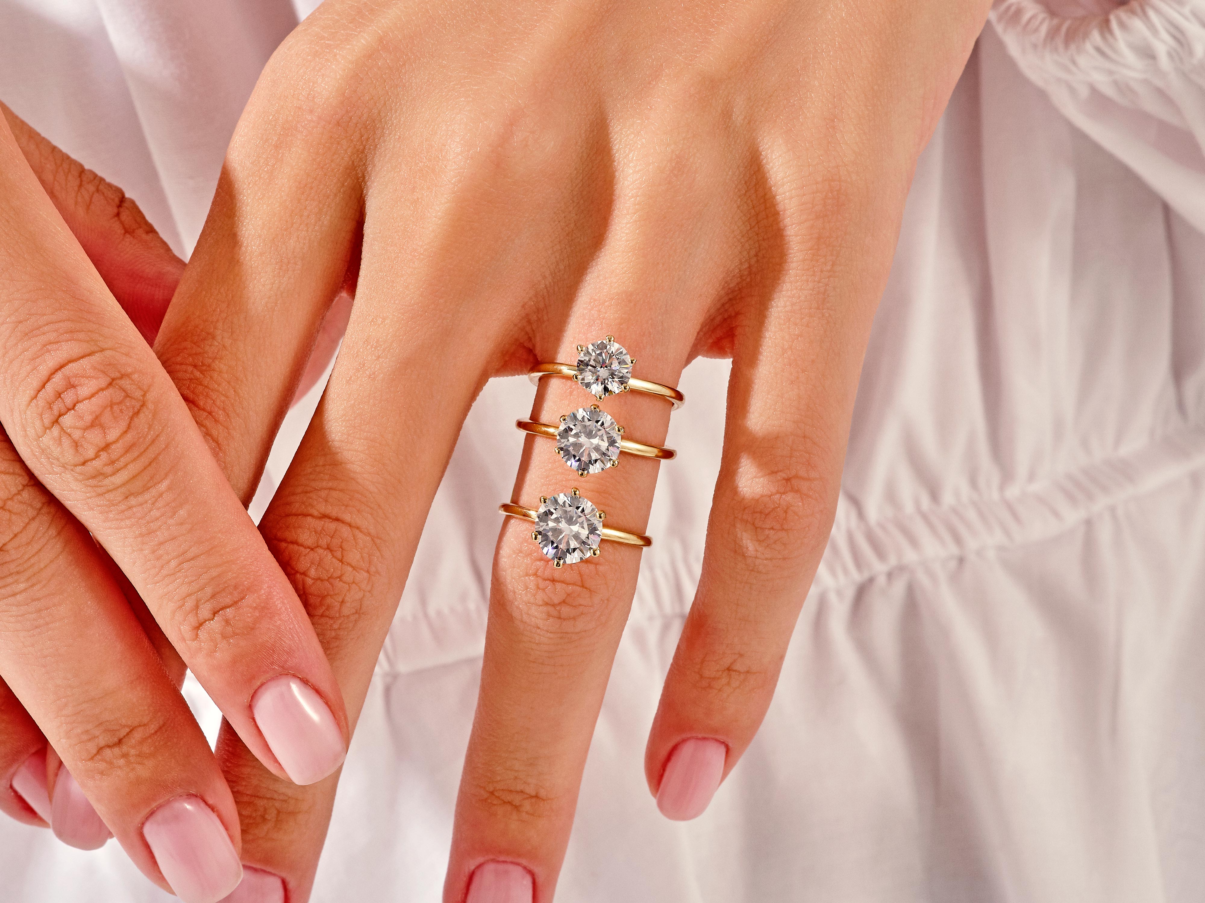 Diamond solitaire rings on a hand, jewelry photography