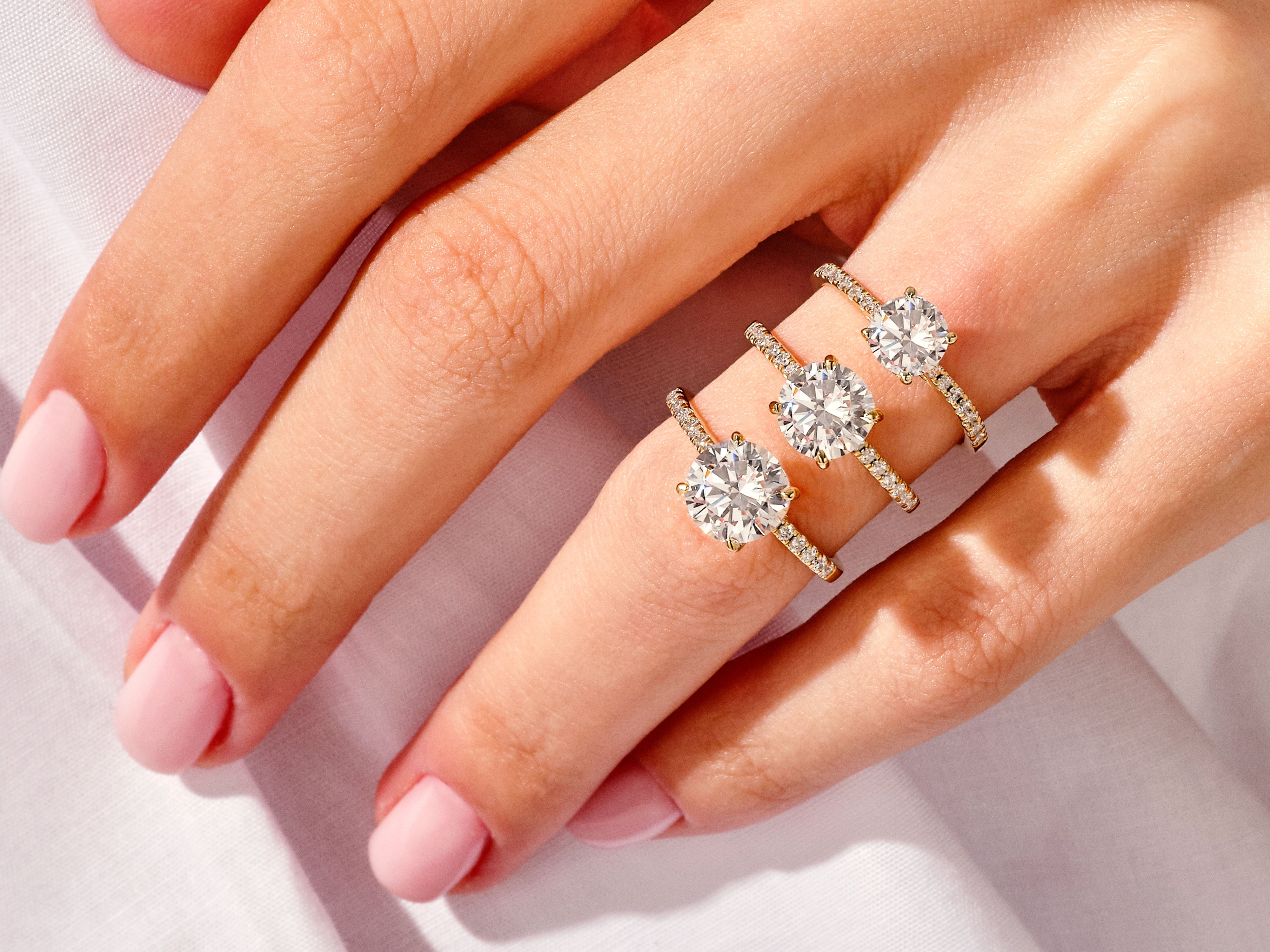 Diamond engagement rings on a hand, jewelry collection