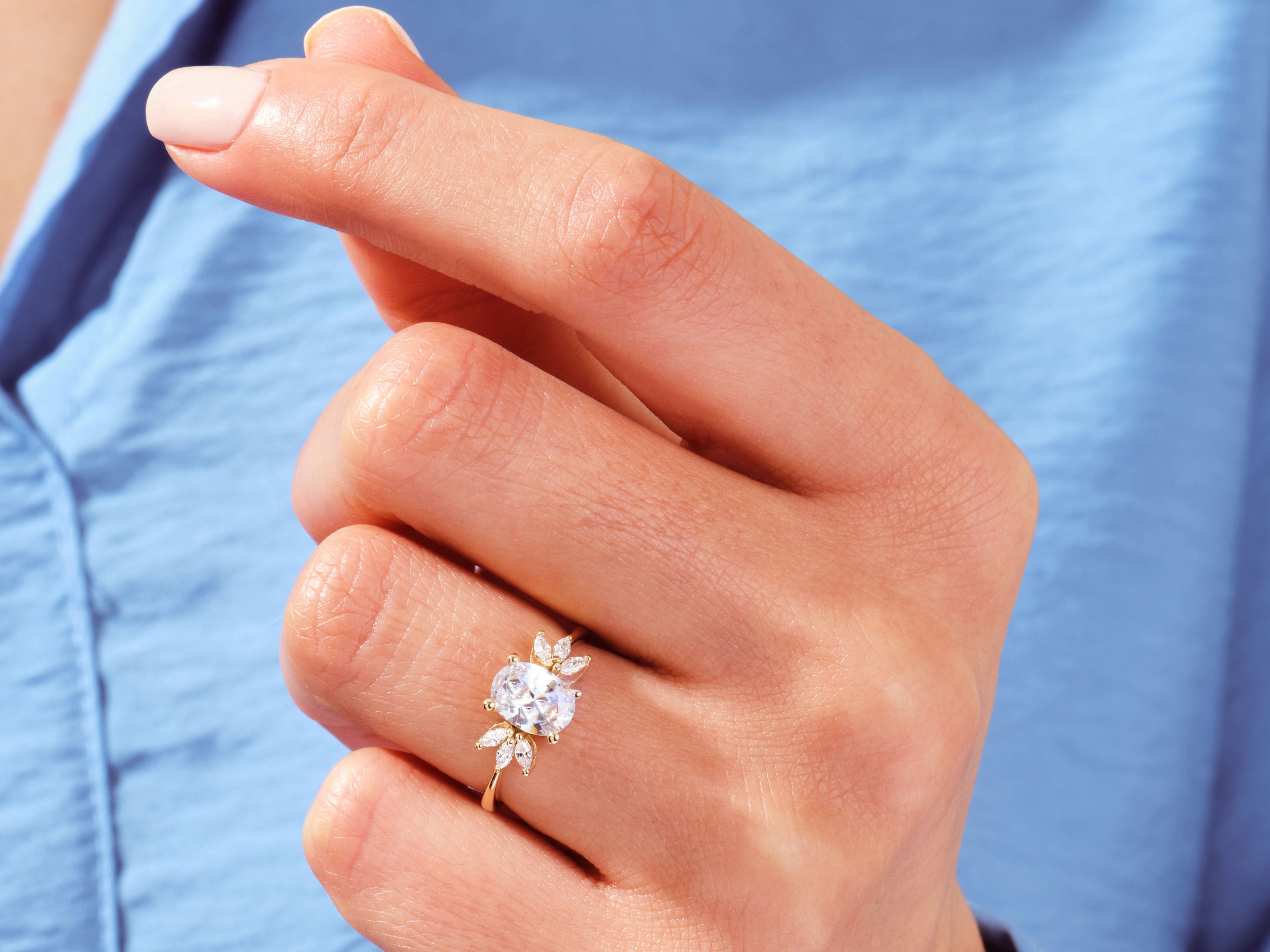 Gold oval diamond engagement ring on hand