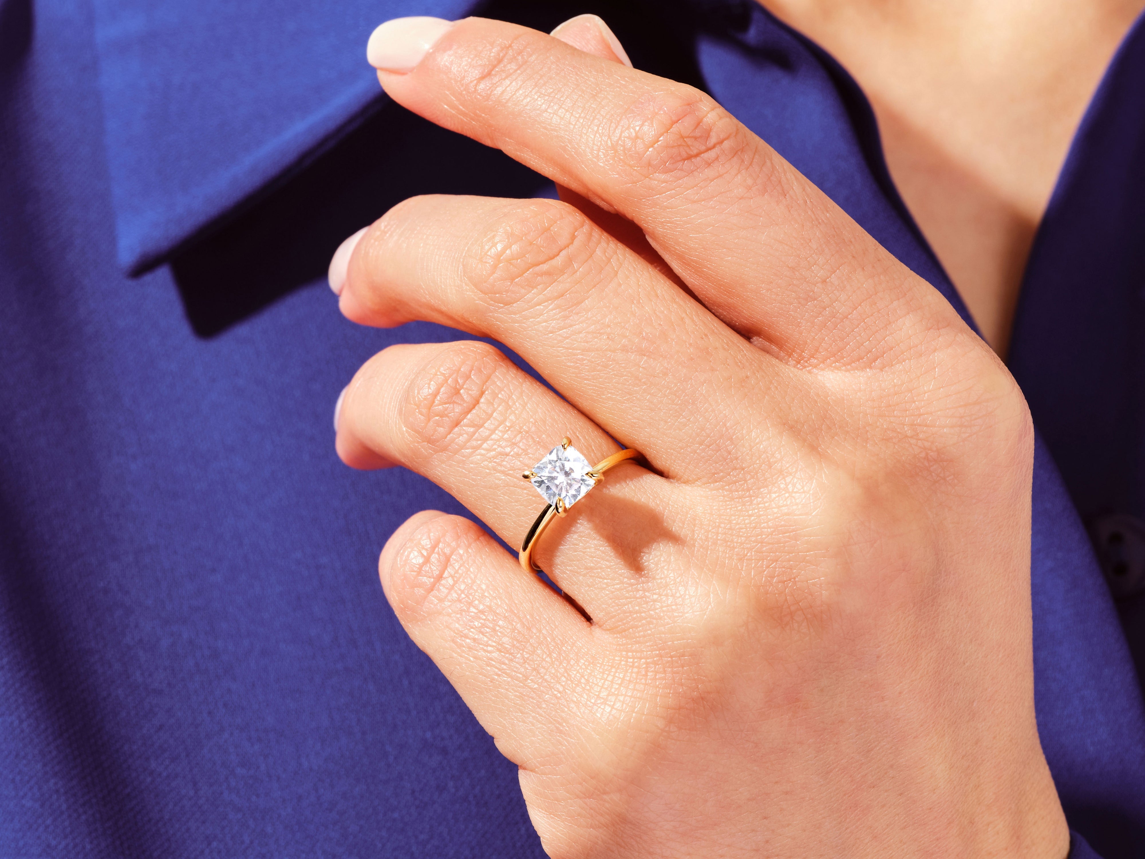 Gold princess cut diamond ring on hand