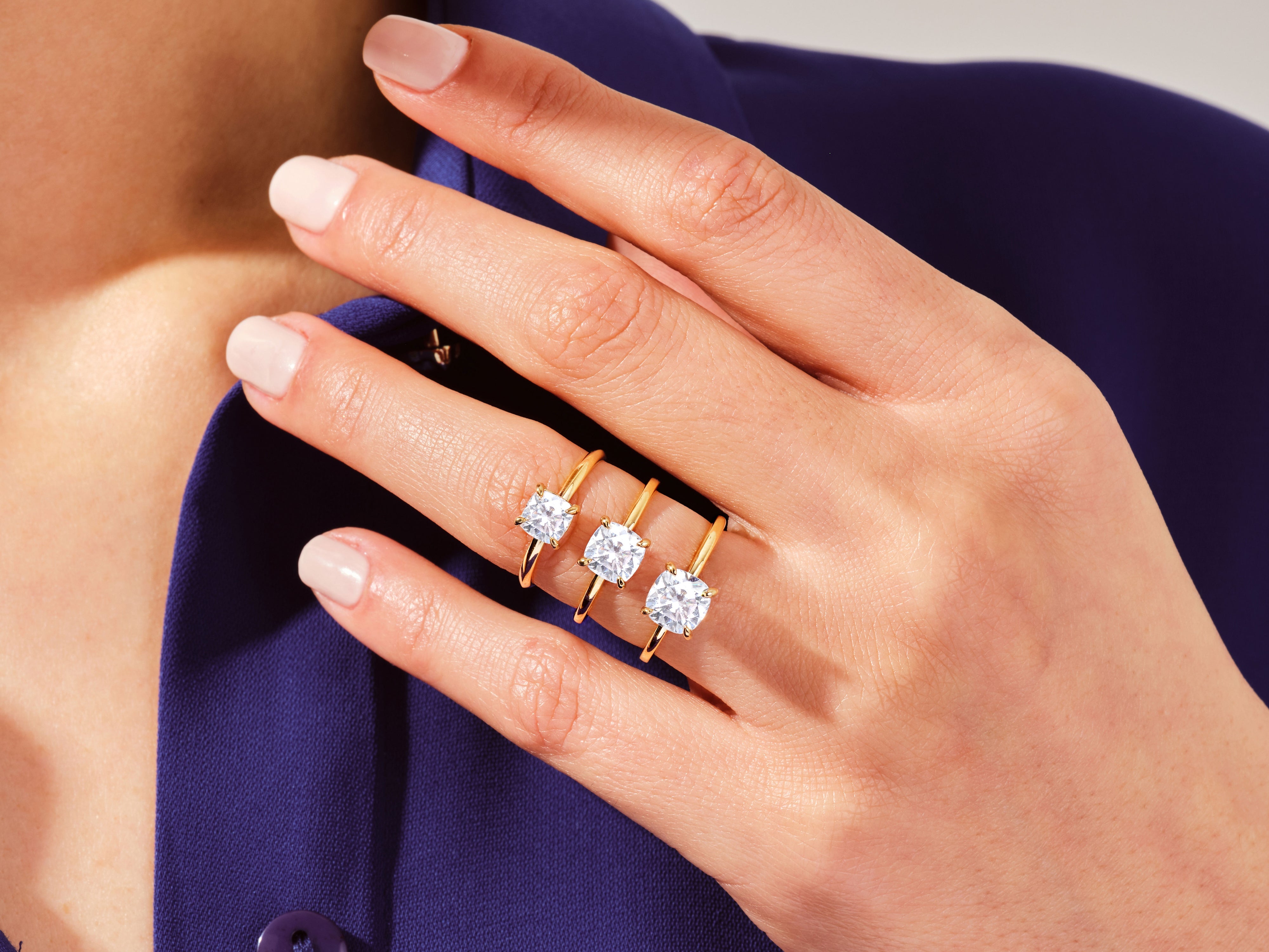 Gold rings with square cut diamonds on a hand