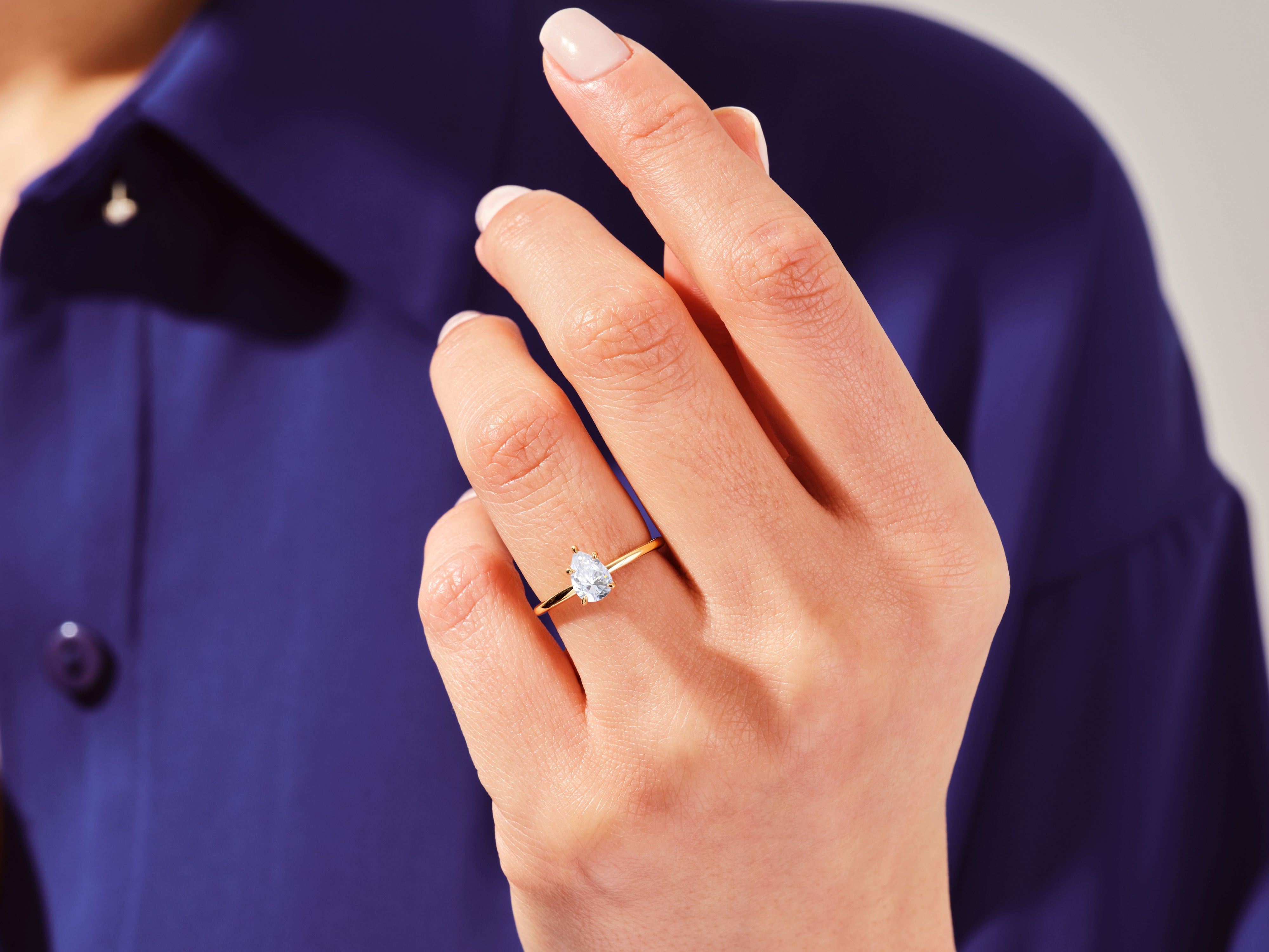 Pear-shaped diamond ring on a woman's finger, jewelry