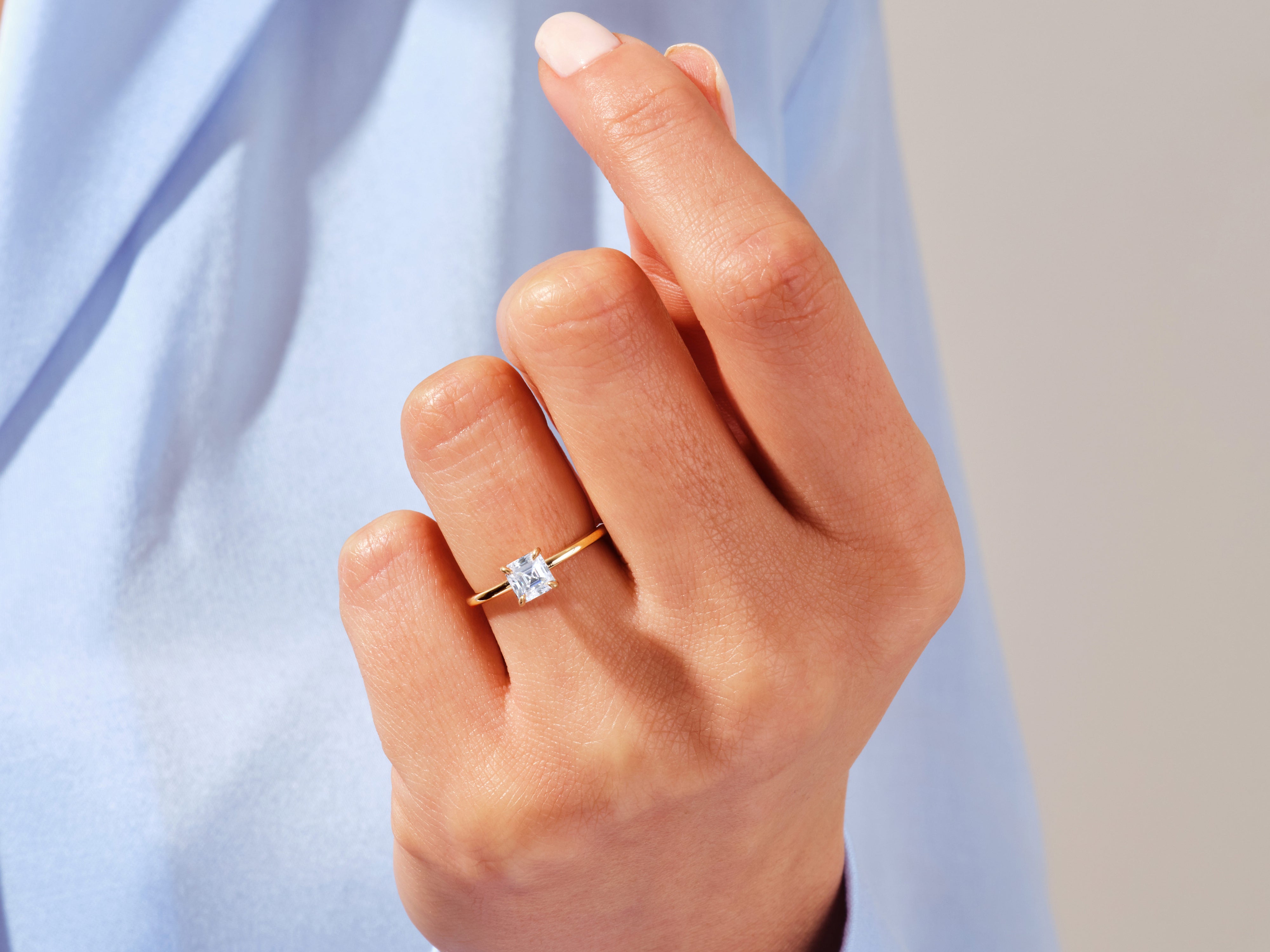 Gold ring with princess cut diamond on hand
