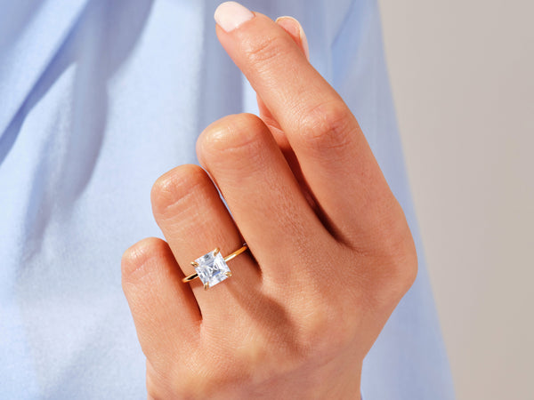 Gold ring with princess cut diamond on hand