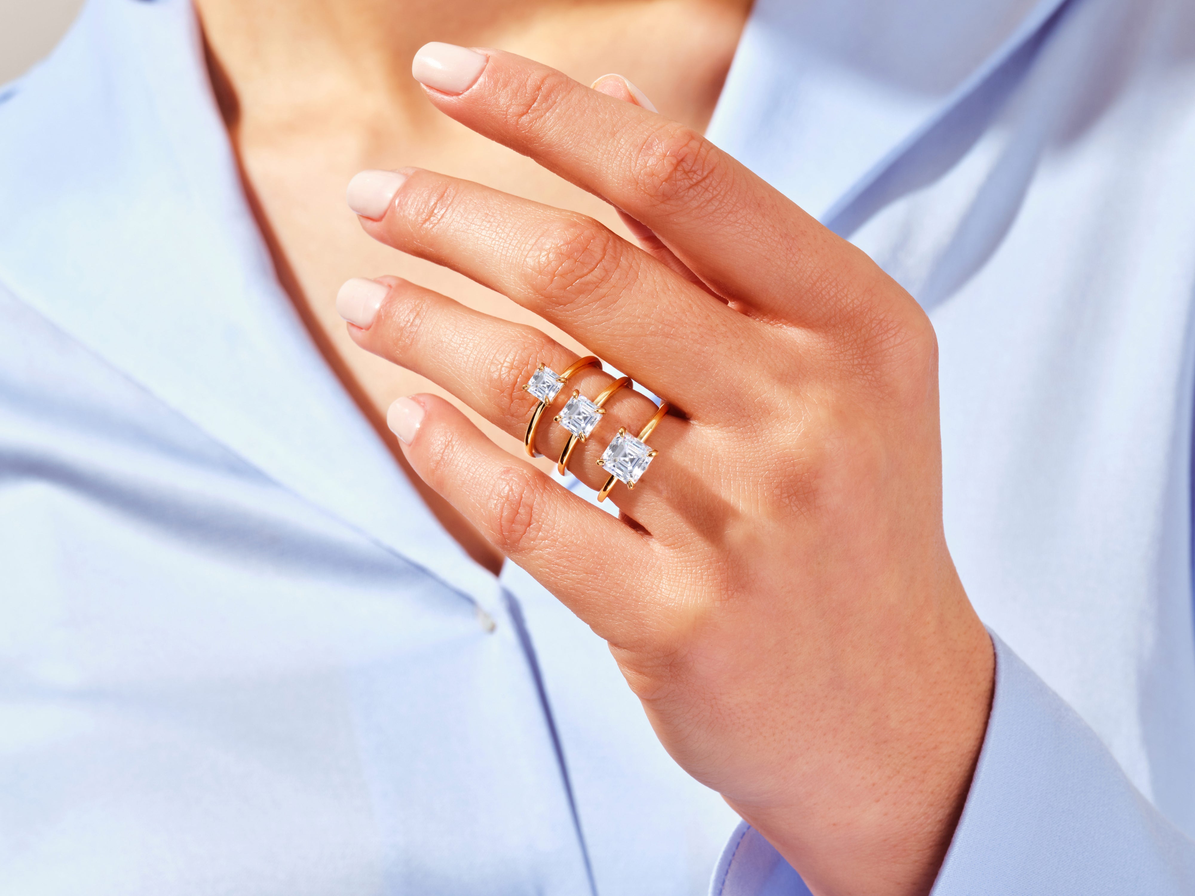 Gold rings with square diamonds on a woman's hand