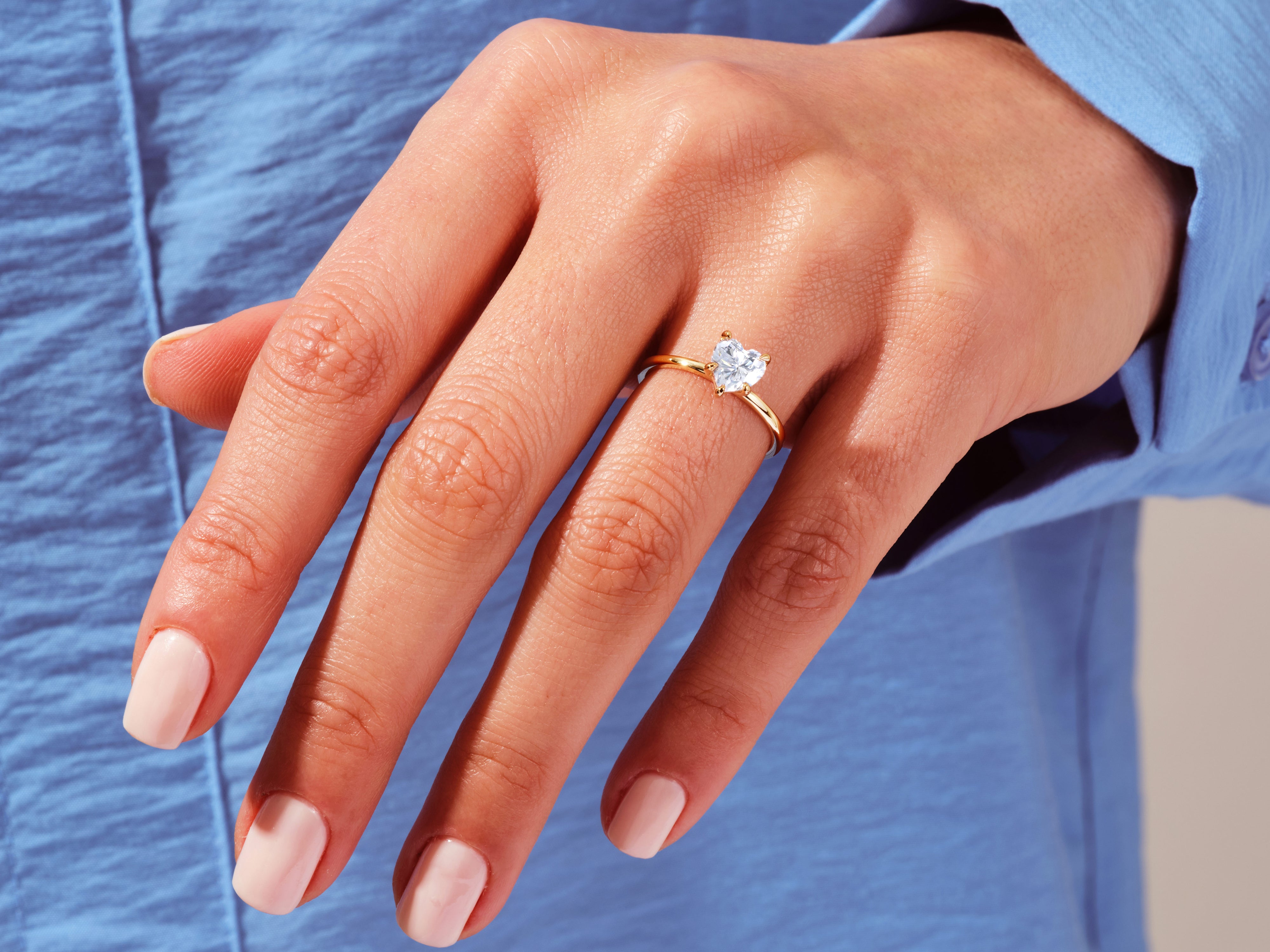 Heart-shaped diamond engagement ring on a woman's hand