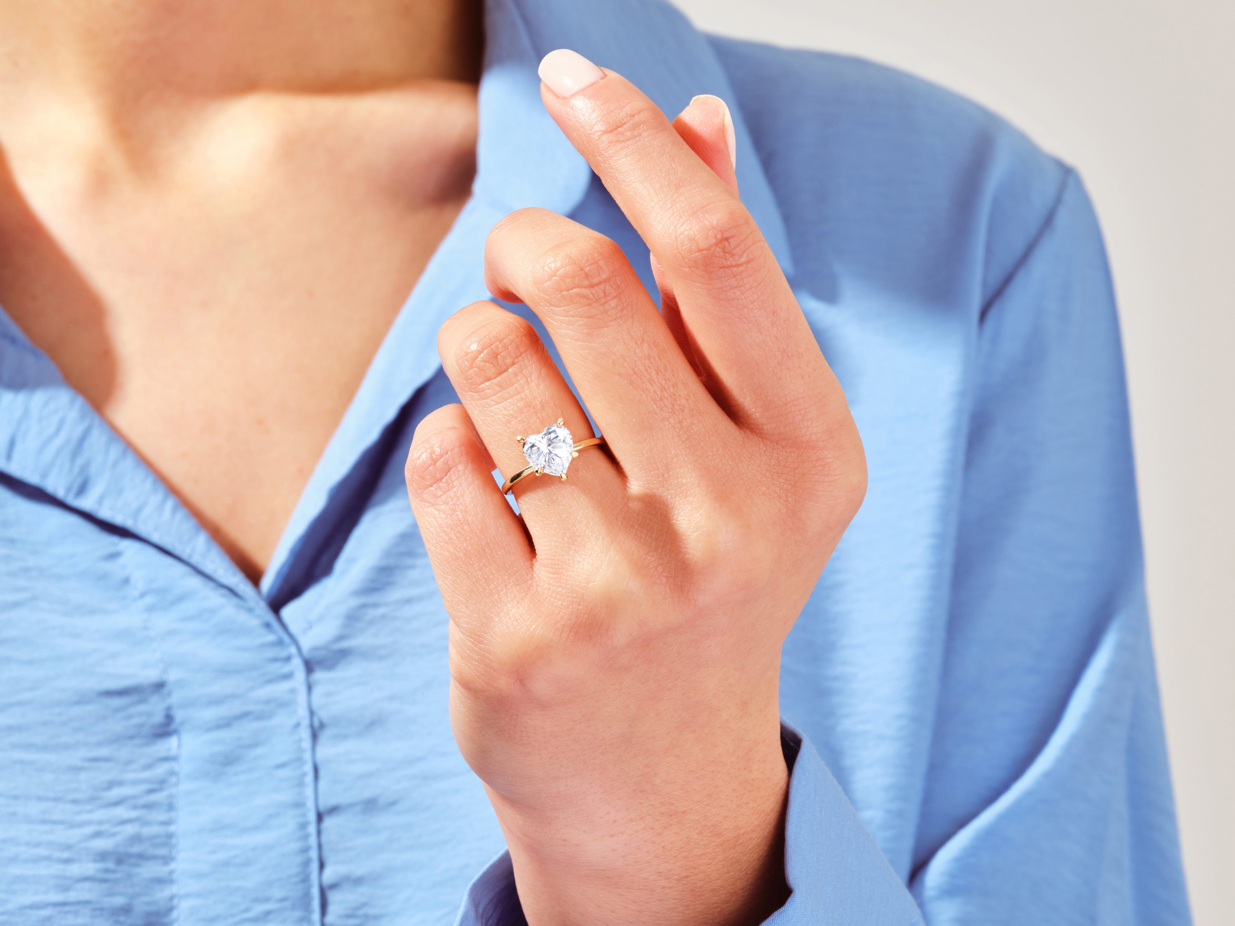 Heart-shaped diamond ring on a woman's finger, jewelry product