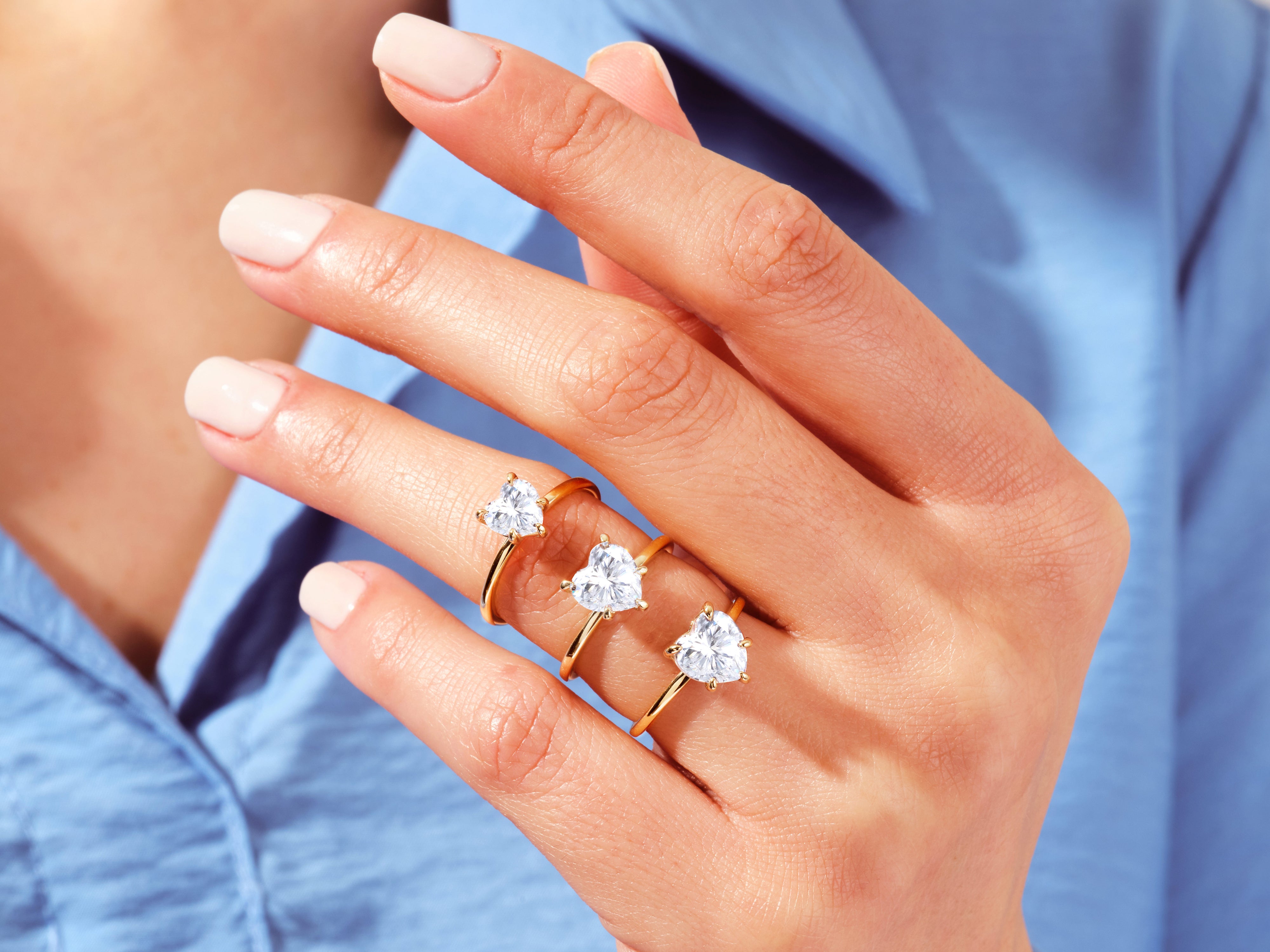 Gold heart diamond rings on a hand, jewelry collection