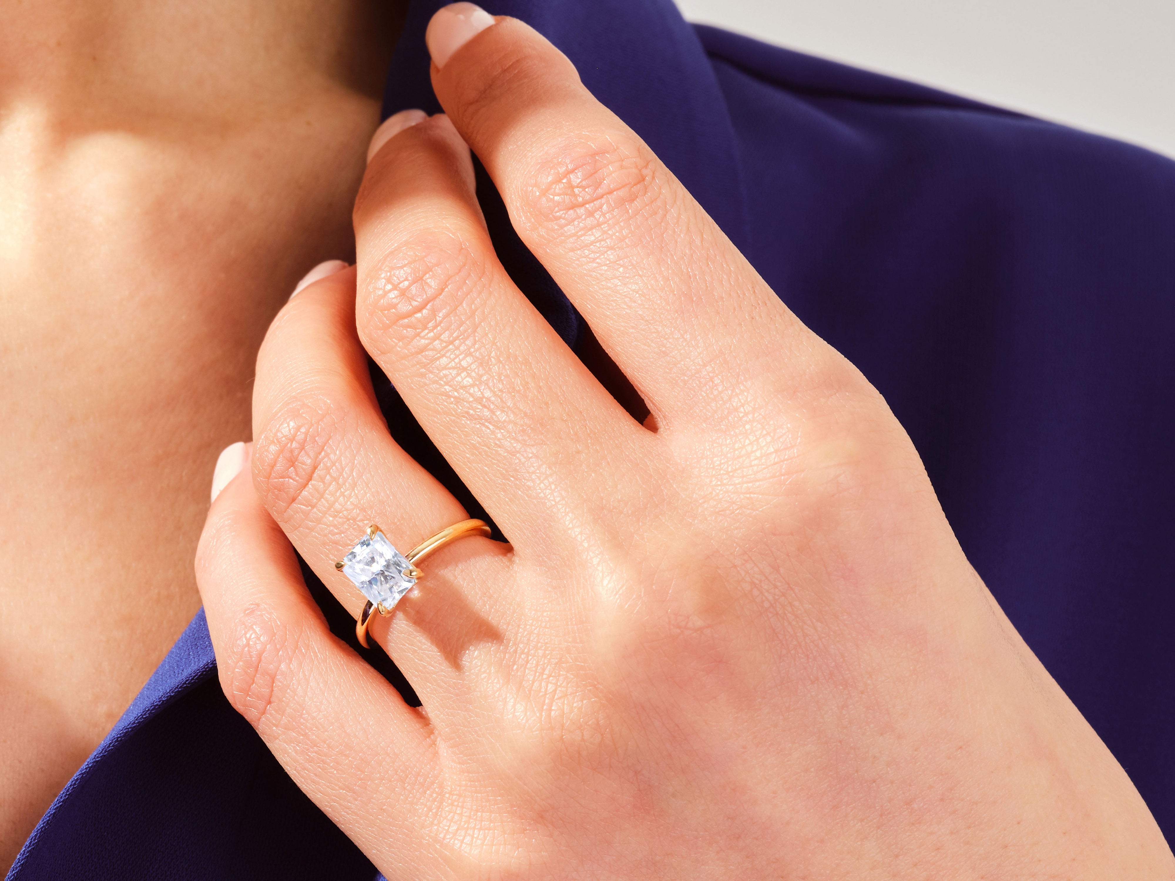 Gold ring with radiant cut diamond on hand