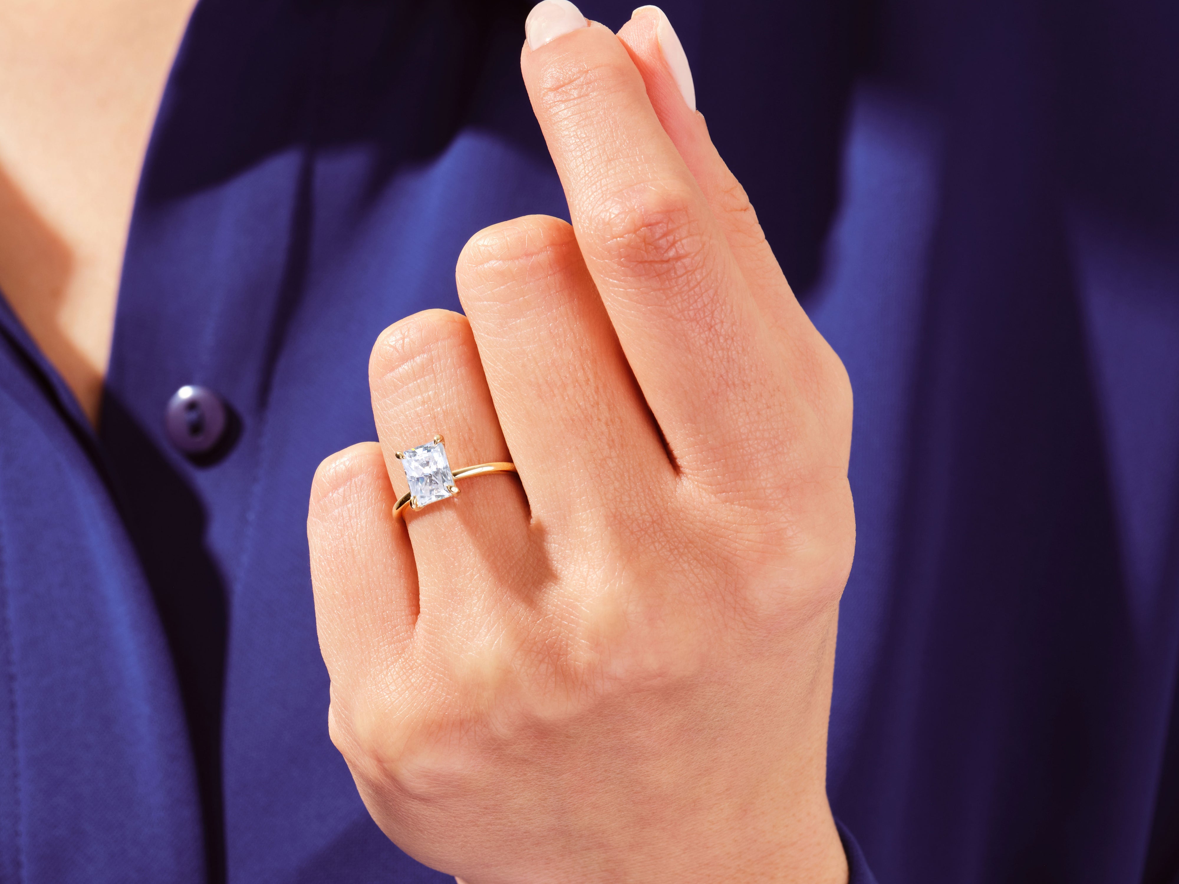 Radiant emerald cut diamond ring on a woman's finger