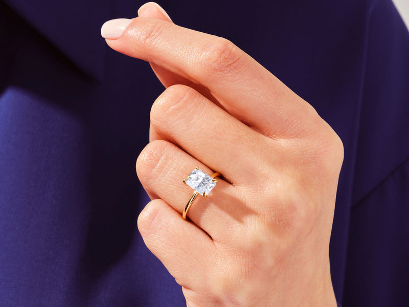Gold ring with radiant cut diamond on hand