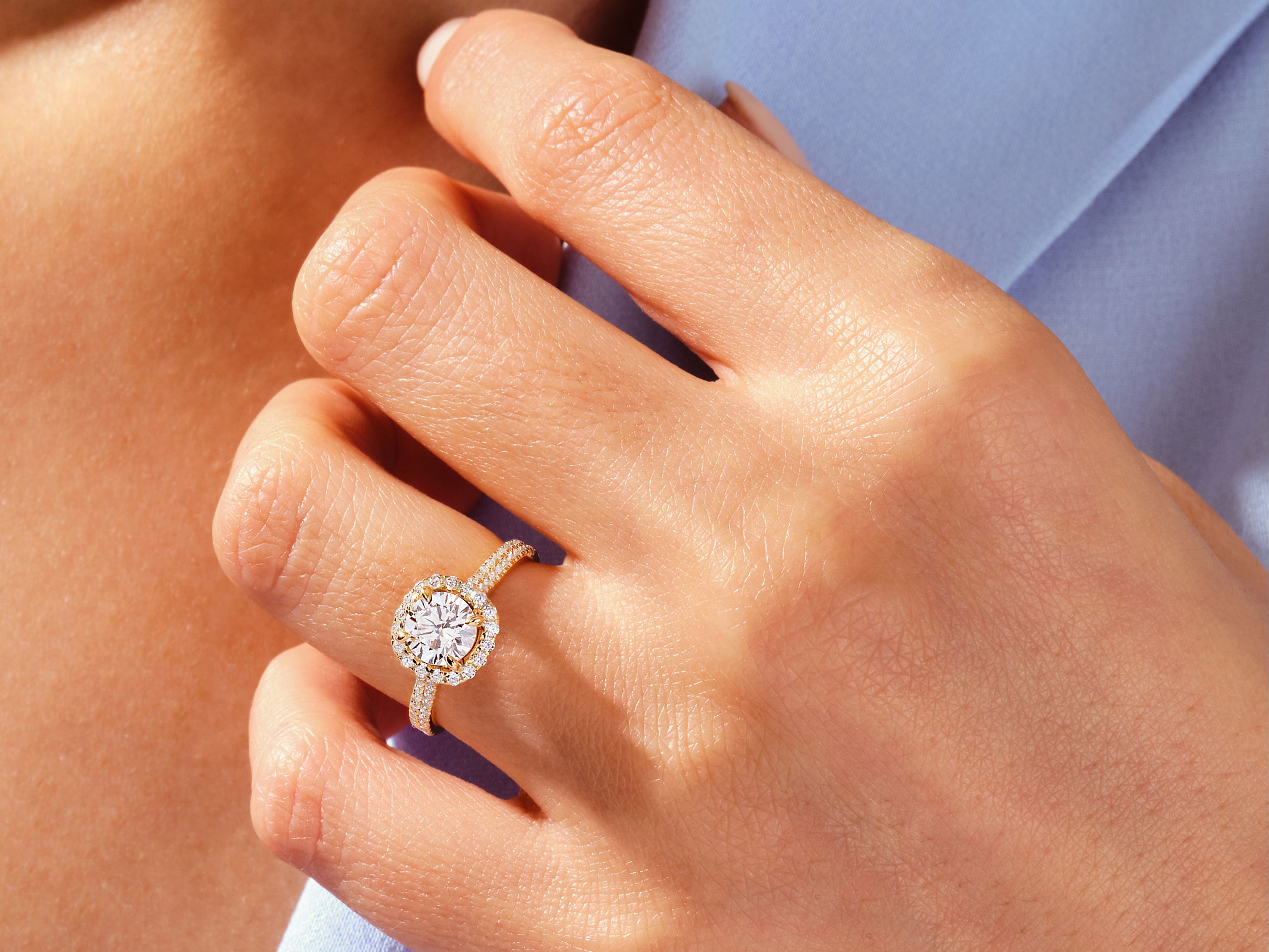 Diamond halo engagement ring on a woman's hand