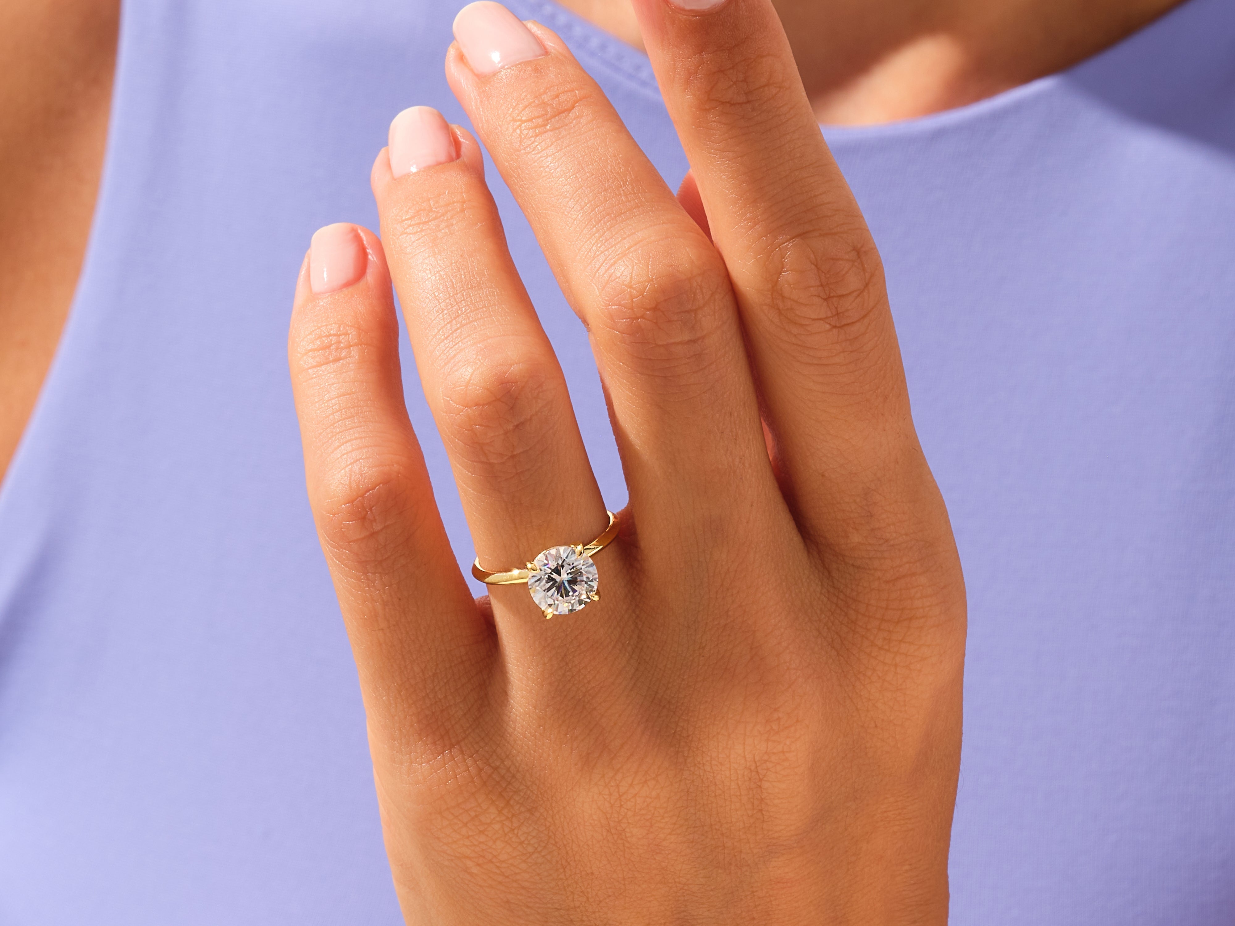 Gold solitaire ring with a large diamond on a woman's hand