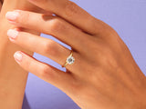 Gold solitaire ring on a hand, jewelry product photography