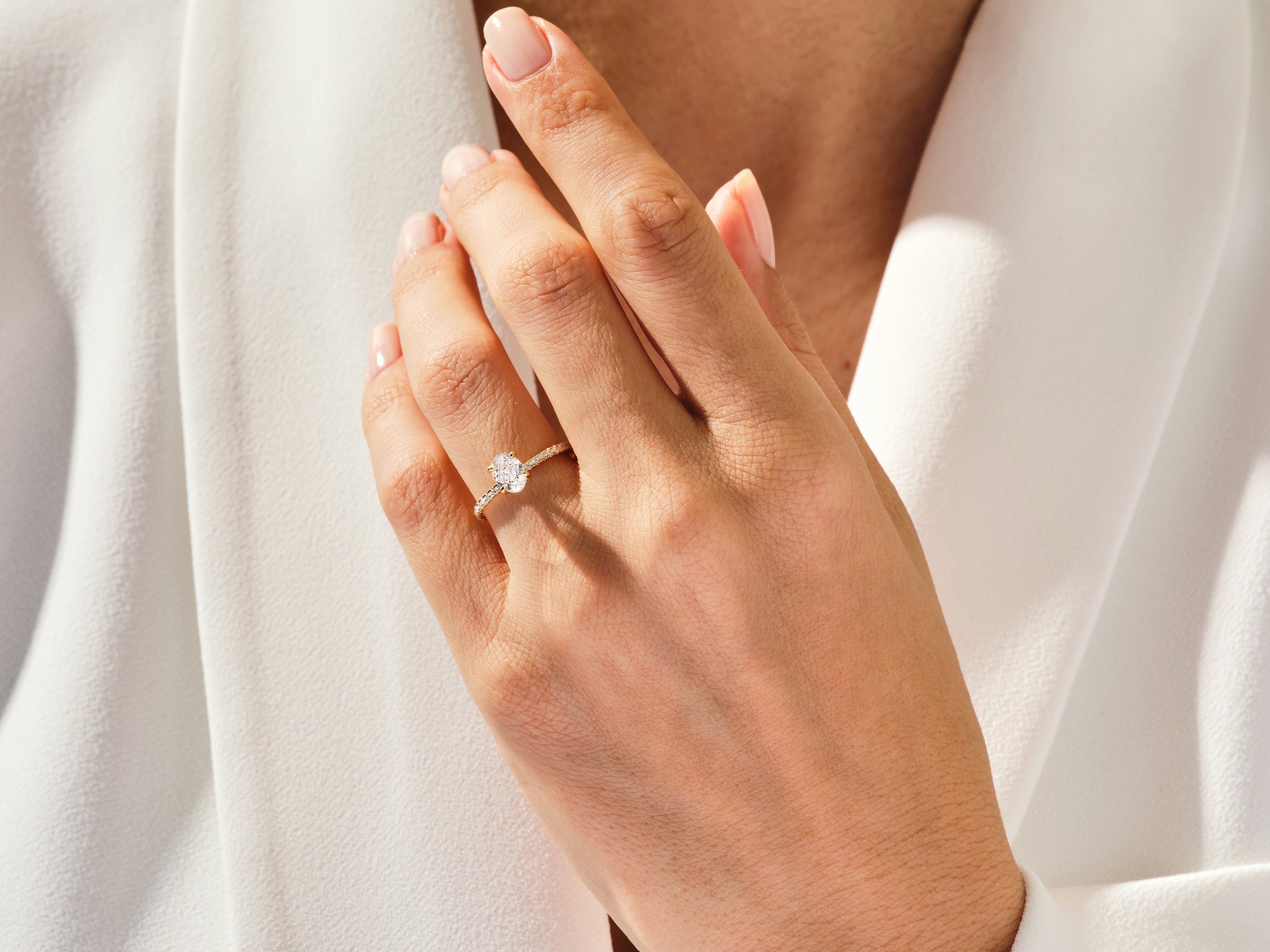 Gold oval diamond engagement ring on a woman's hand