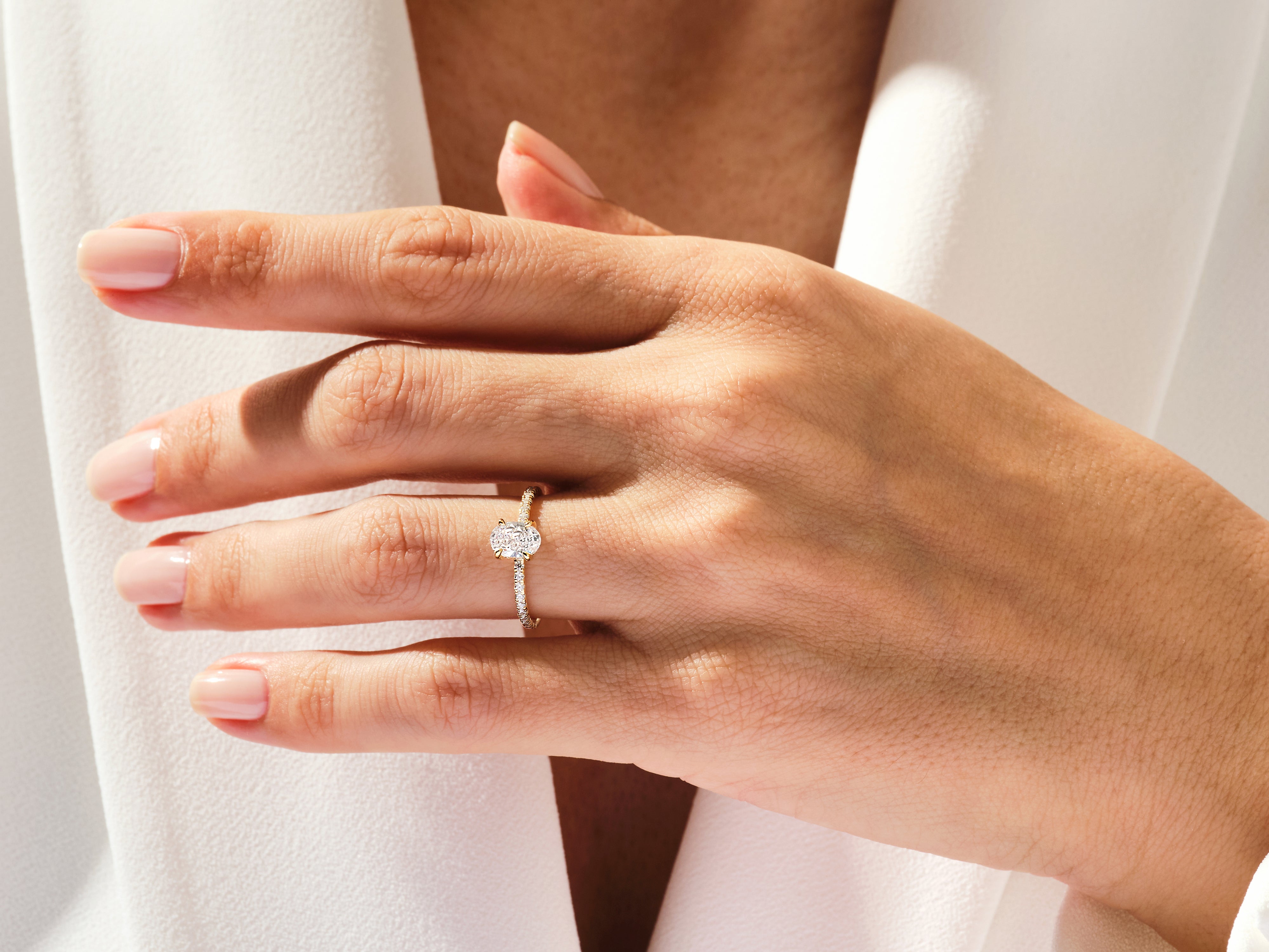 Oval diamond engagement ring on a hand, fine jewelry