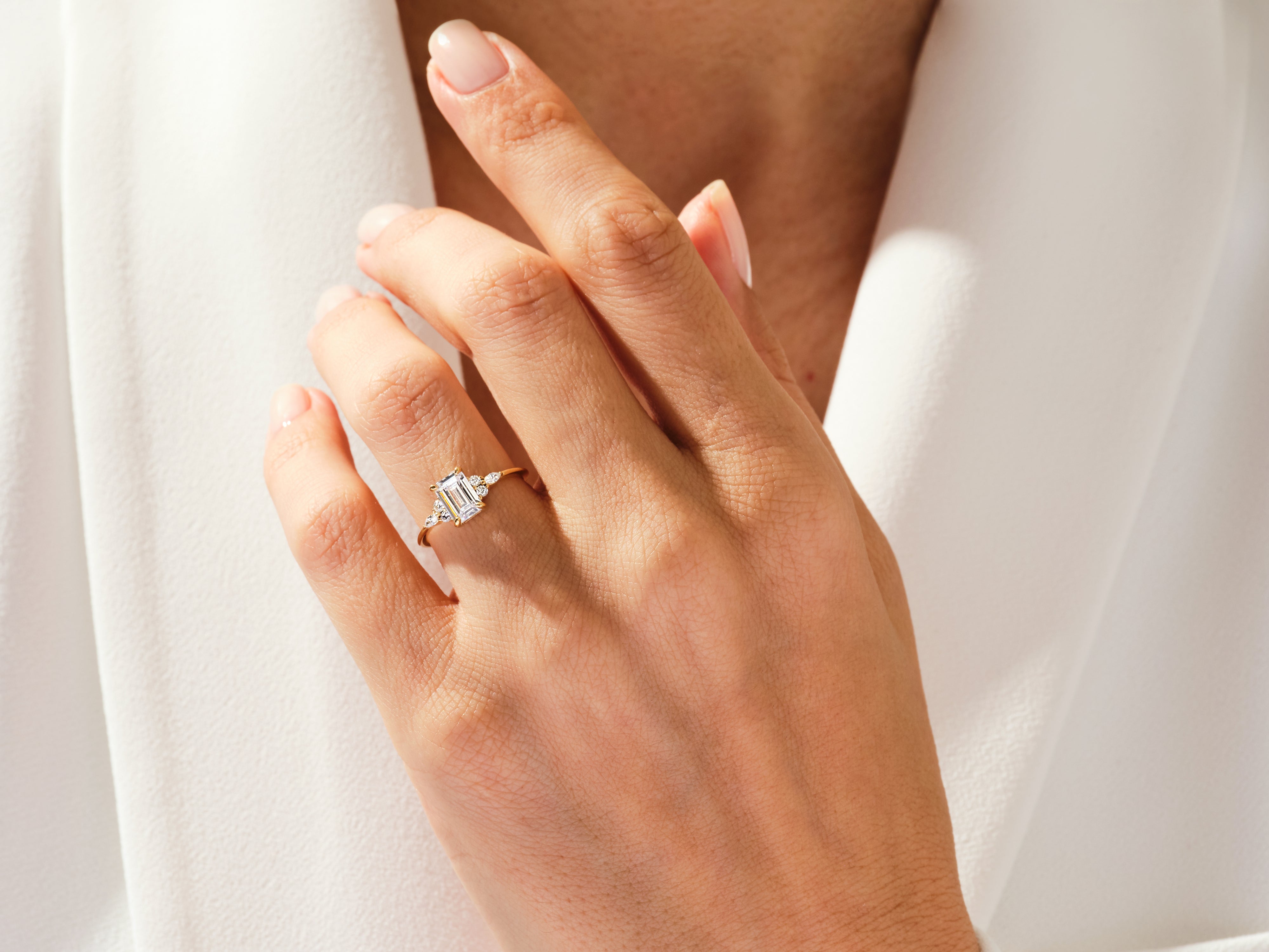 Emerald cut diamond ring on a hand, jewelry firm product