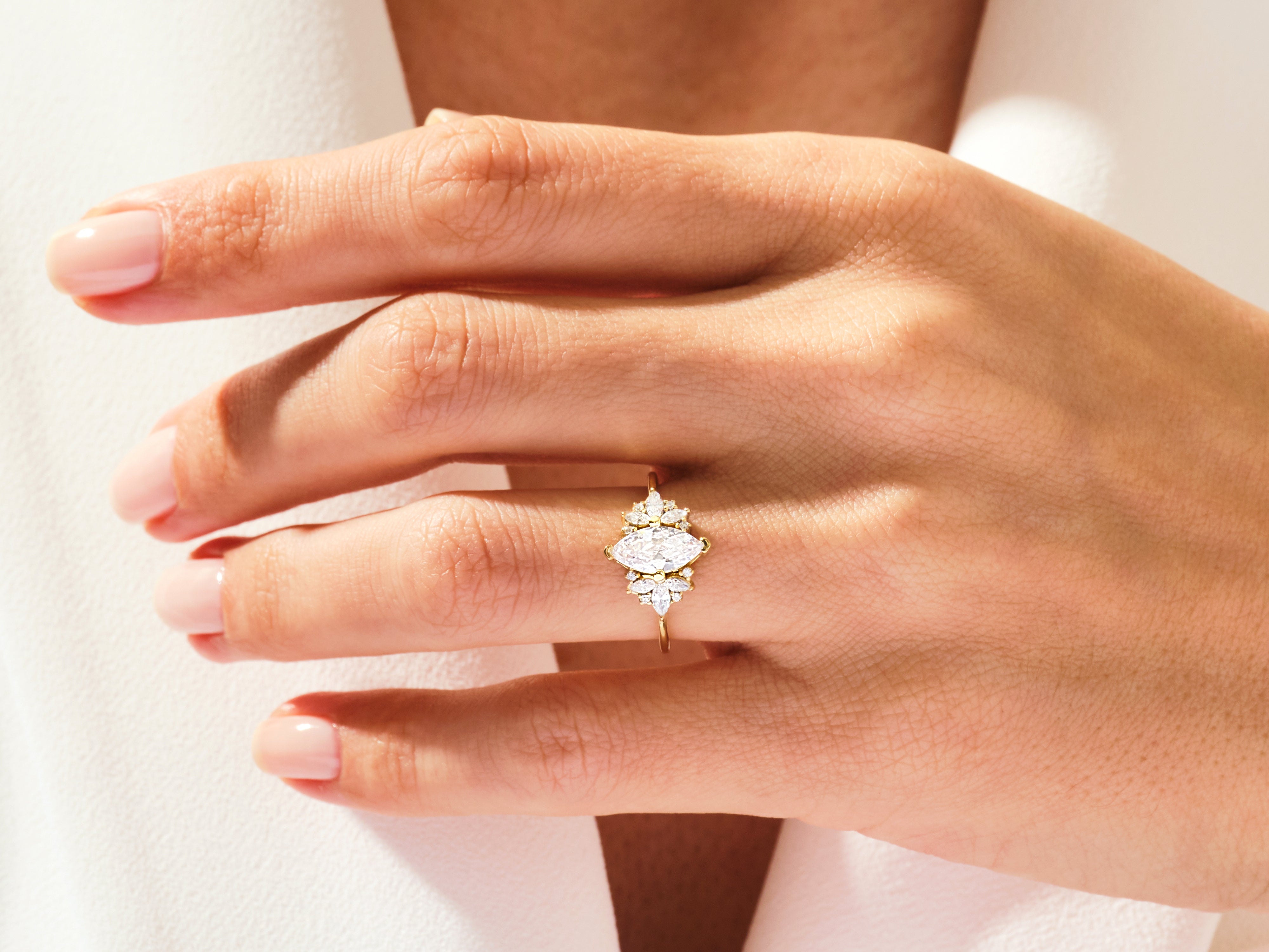 Marquise diamond engagement ring with accent stones on a hand