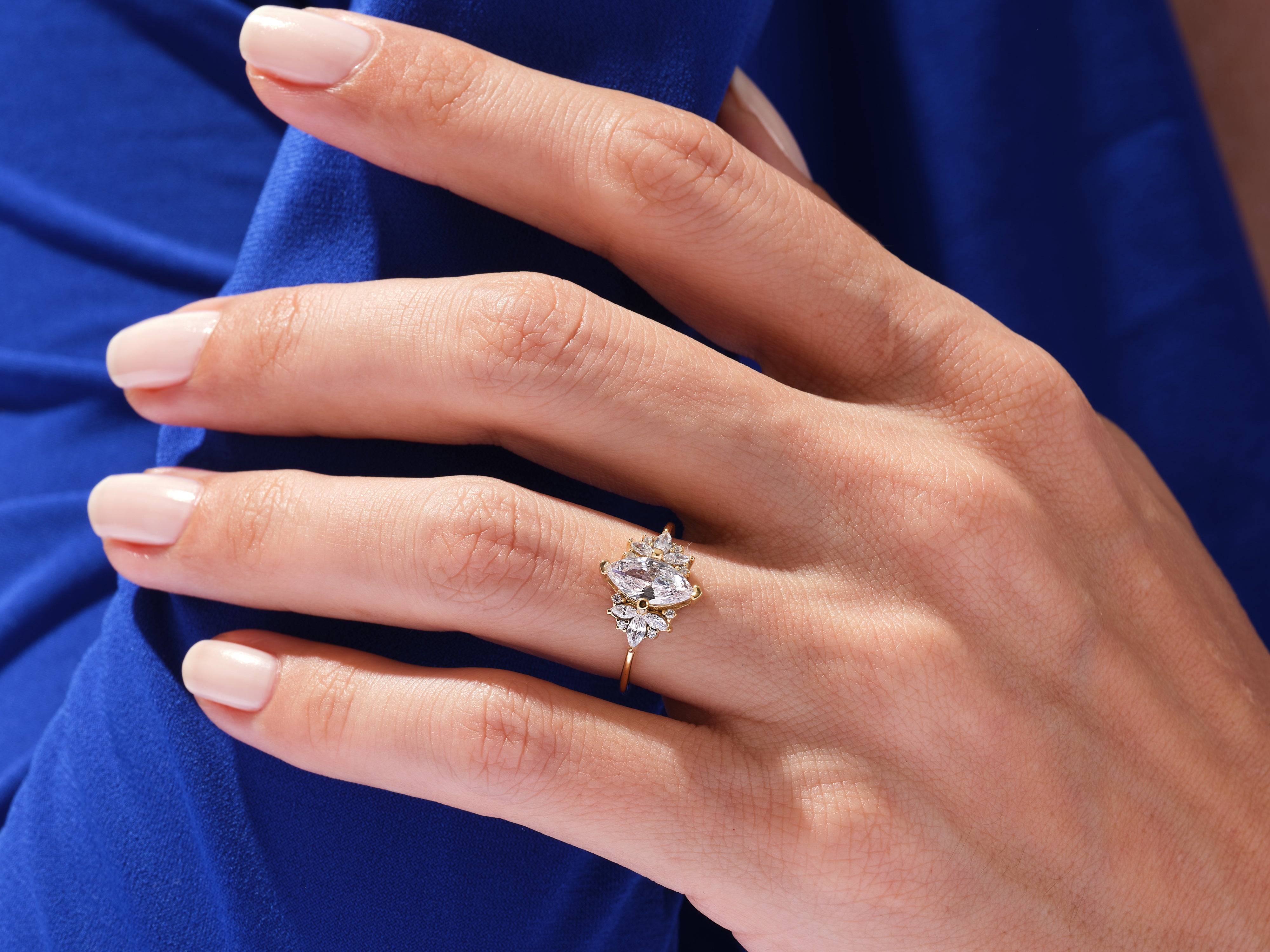 Gold ring with marquise and round diamonds on hand