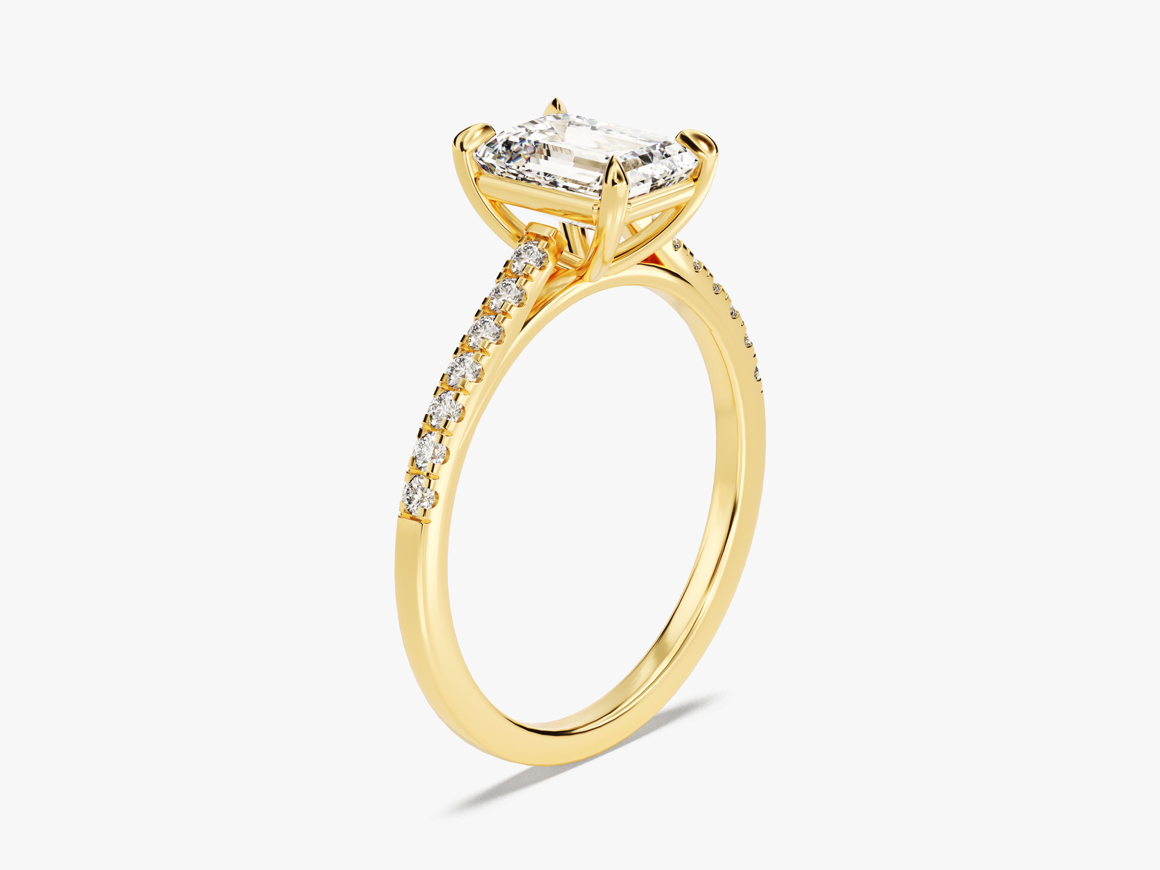 Gold engagement ring with emerald cut diamond and pave band