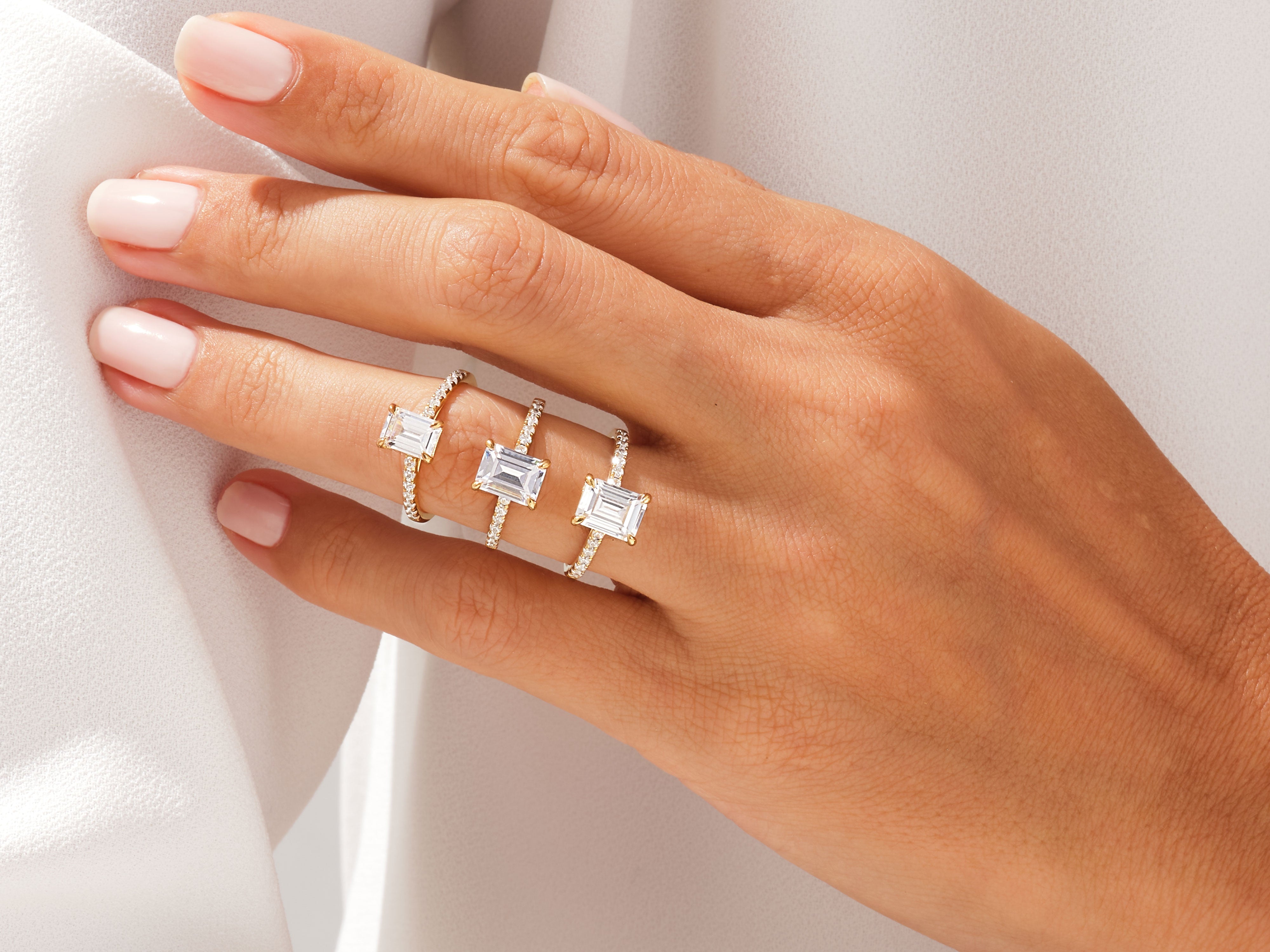 Emerald cut diamond rings on a hand, fine jewelry collection