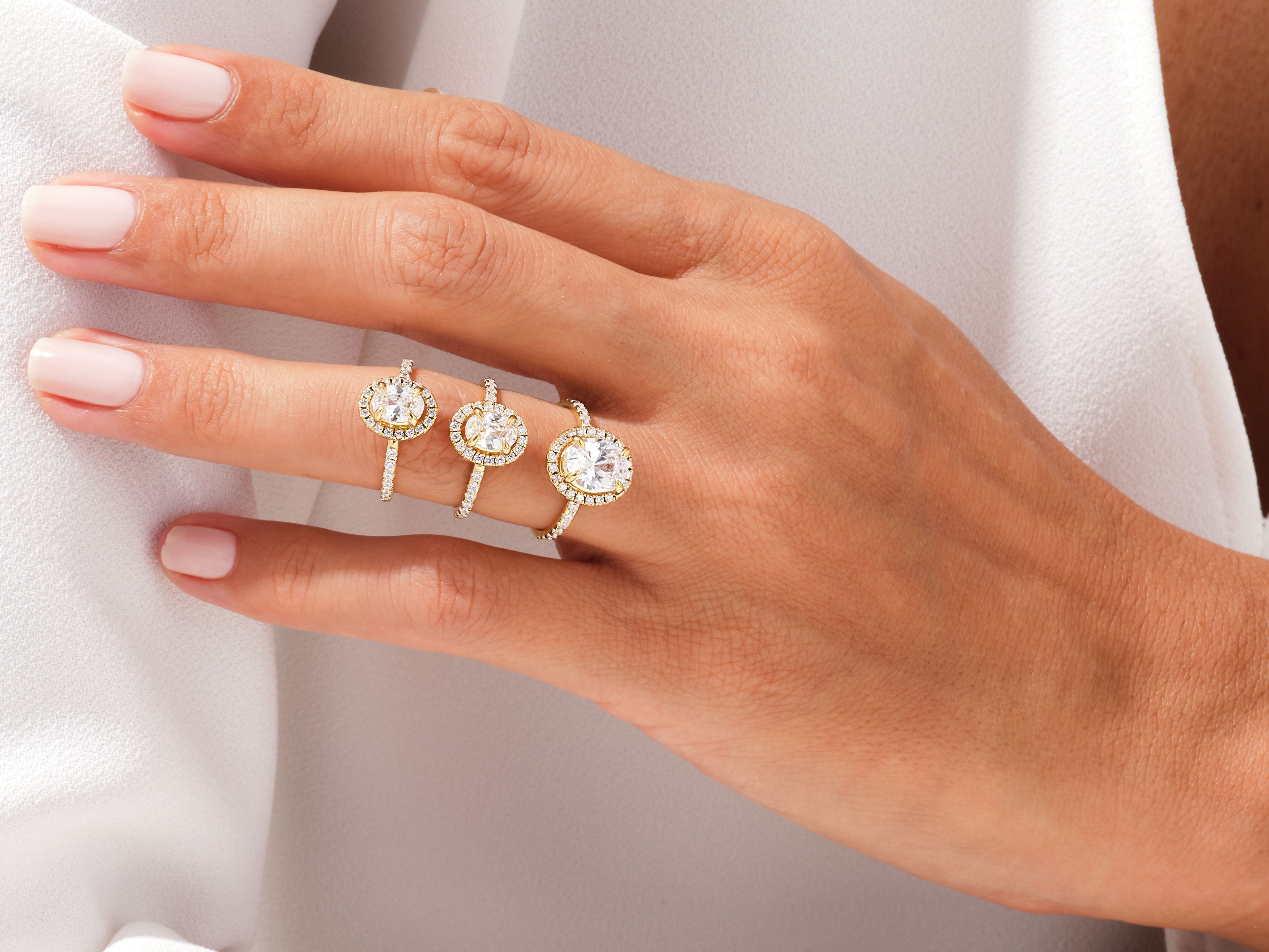 Three diamond halo rings on a hand, jewelry