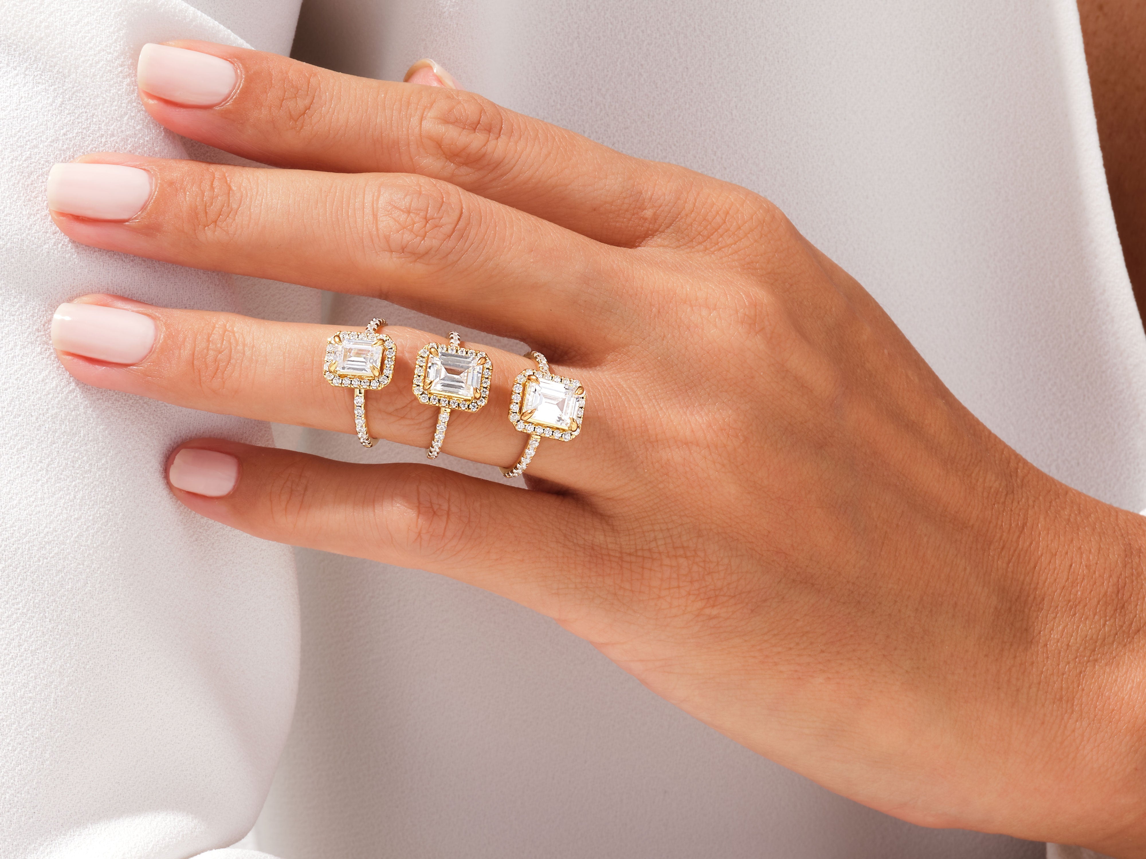 Three diamond halo rings on a hand