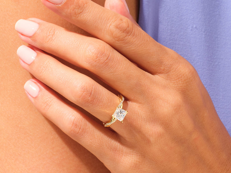Gold princess cut diamond ring on a woman's hand