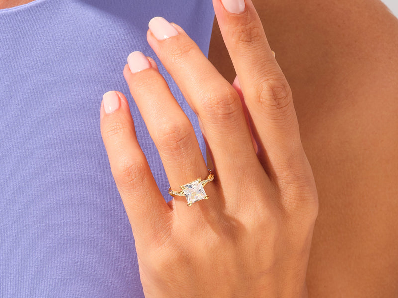 Gold princess cut diamond engagement ring on hand