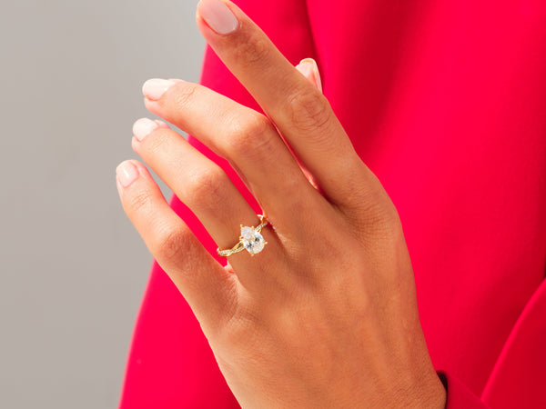 Gold pear-shaped diamond ring on a hand