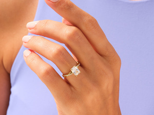Gold ring with princess cut diamond on a woman's hand