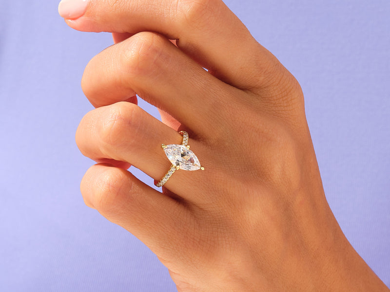 Marquise diamond engagement ring with pave band on hand