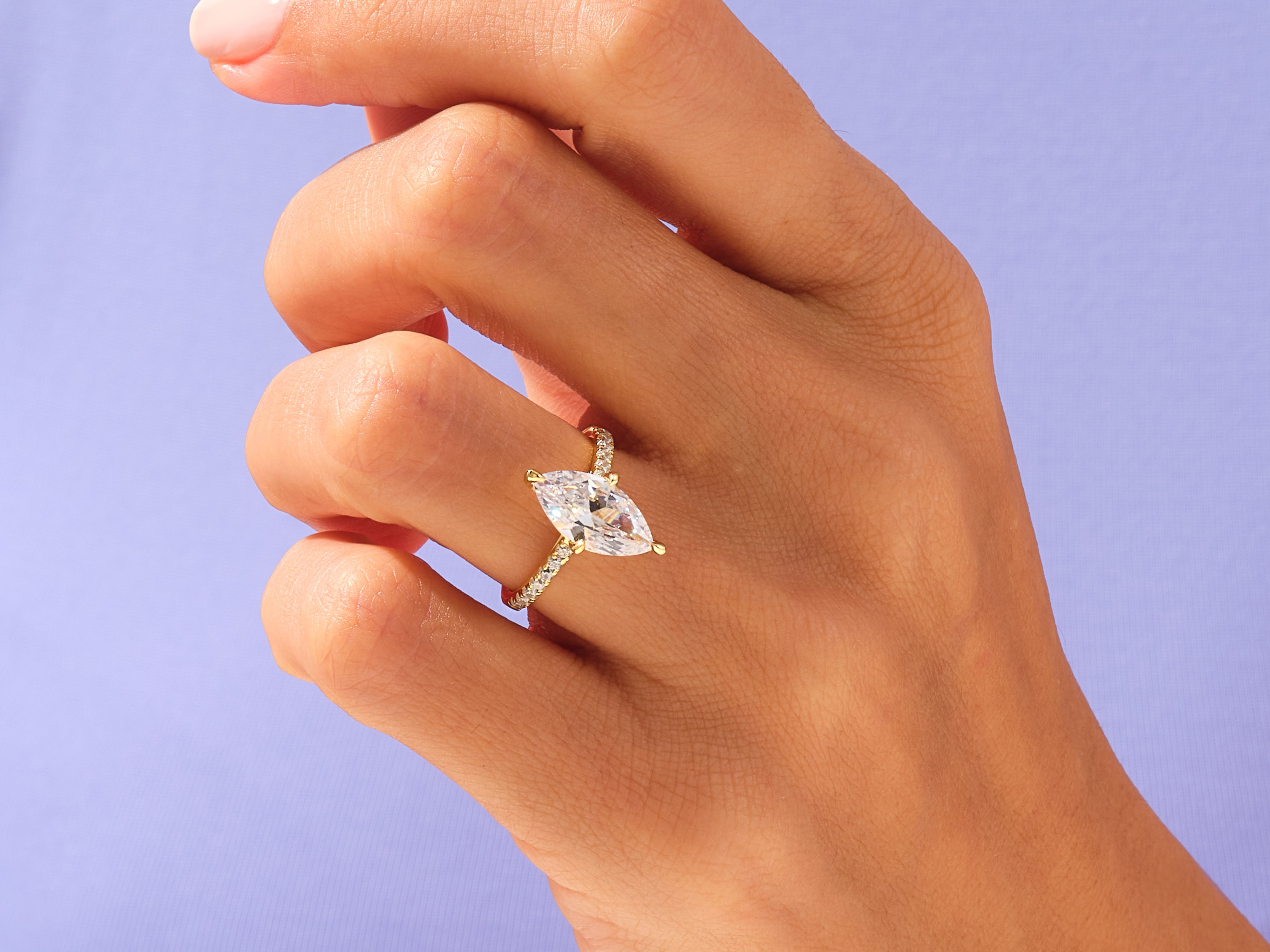 Marquise diamond engagement ring with pave band on hand